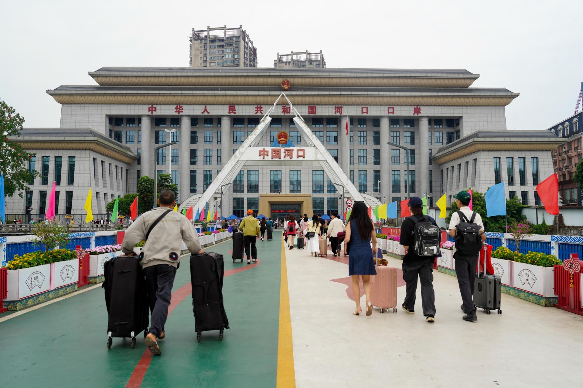 5月1日，旅客在中越边境河口口岸南溪河公路大桥上通行。