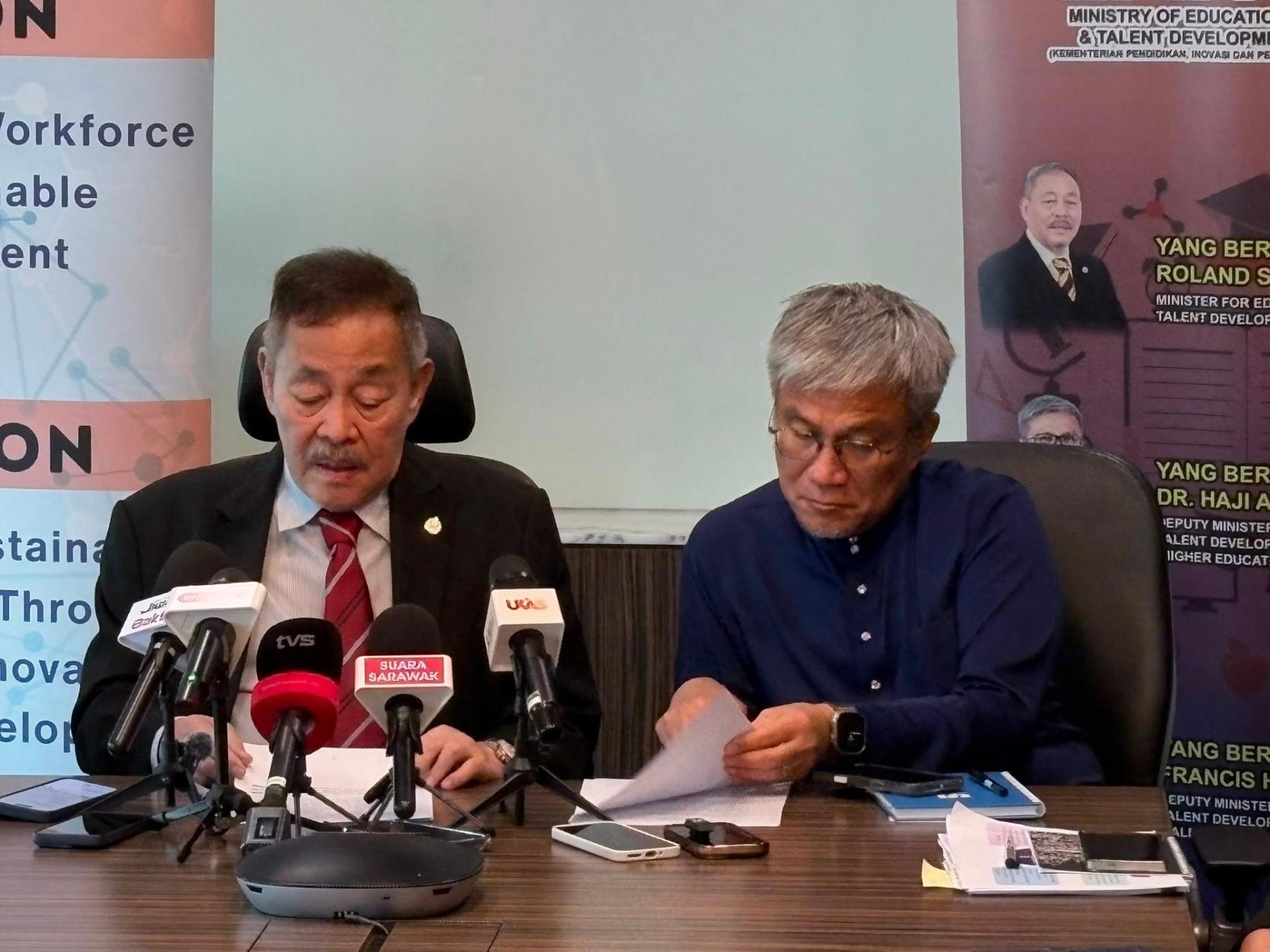 安华拉巴益（右）在翻查资料。左为拿督斯里罗伦沙加。