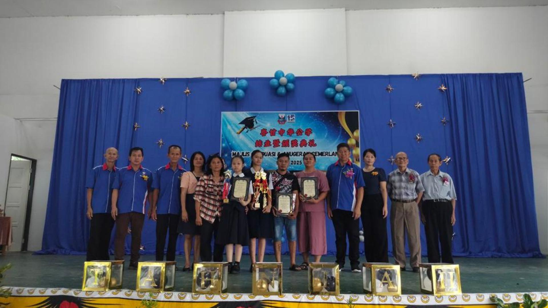峇甘中华公学课外活动杰出奖兼模范生洁希（左7），最佳阅读计划奖黄子萱（左6）领奖时摄  。左起为董事杨永生、董事韩佳兴、董事黄秉和、校长林淑芬;右起为永久名誉顾问杨涪胜、永久名誉顾问陈和兴、董事林丽贞、董事长沈振武。