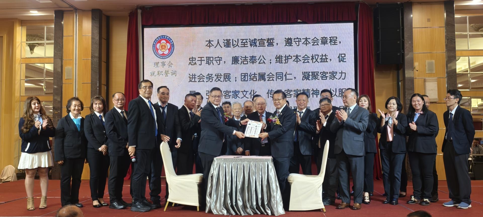砂客联总会新届理事就职签署宣誓书后，与监誓人兼主宾拿督斯里李景胜（前右）合影。前左为砂客联总会长江山河。