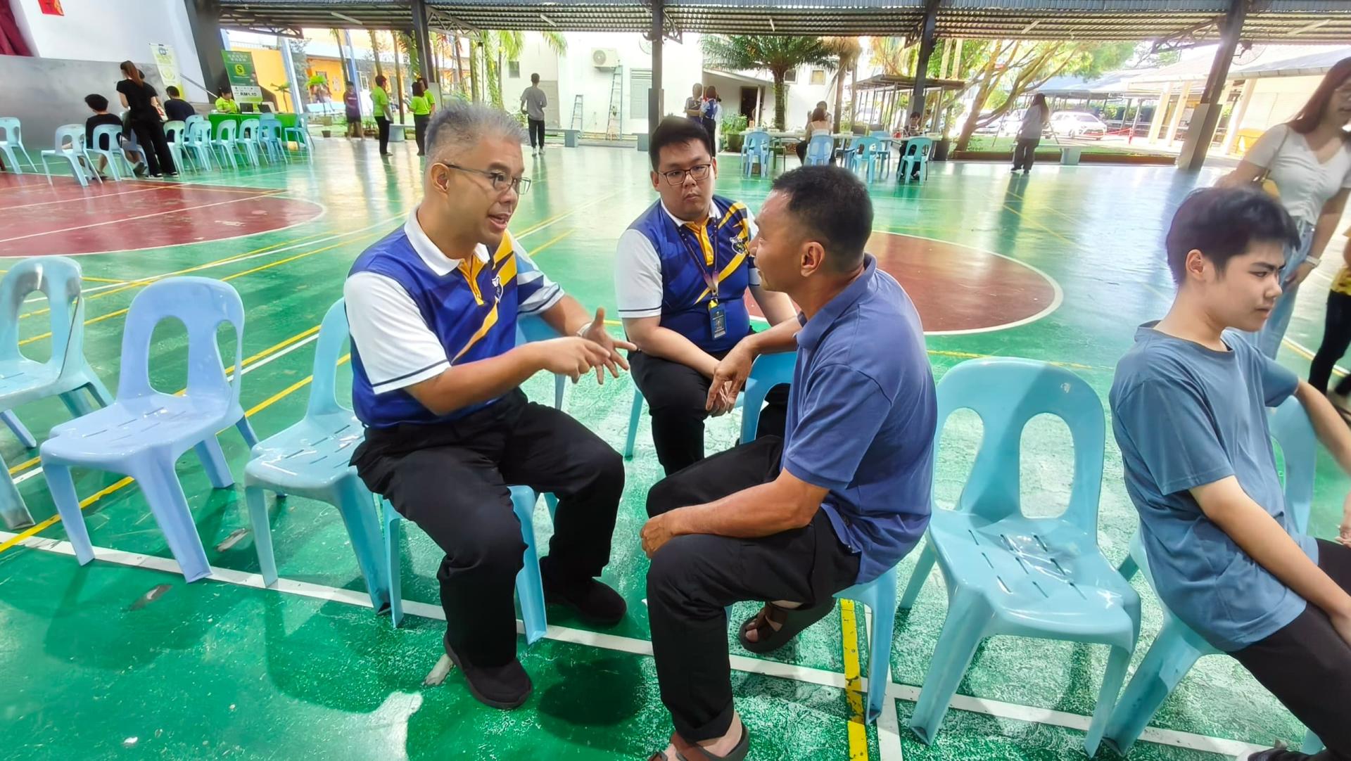 四中校长官晨阳（左）与学生家长亲切交流，了解孩子的学习与成长情况，并携手为孩子未来的发展共同努力。