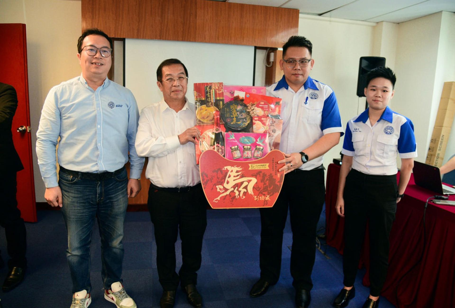 陈国伟（左2）从青运领袖手中接过纪念礼篮，左起为颜丕永、谢伟桐及陈嘉欣。