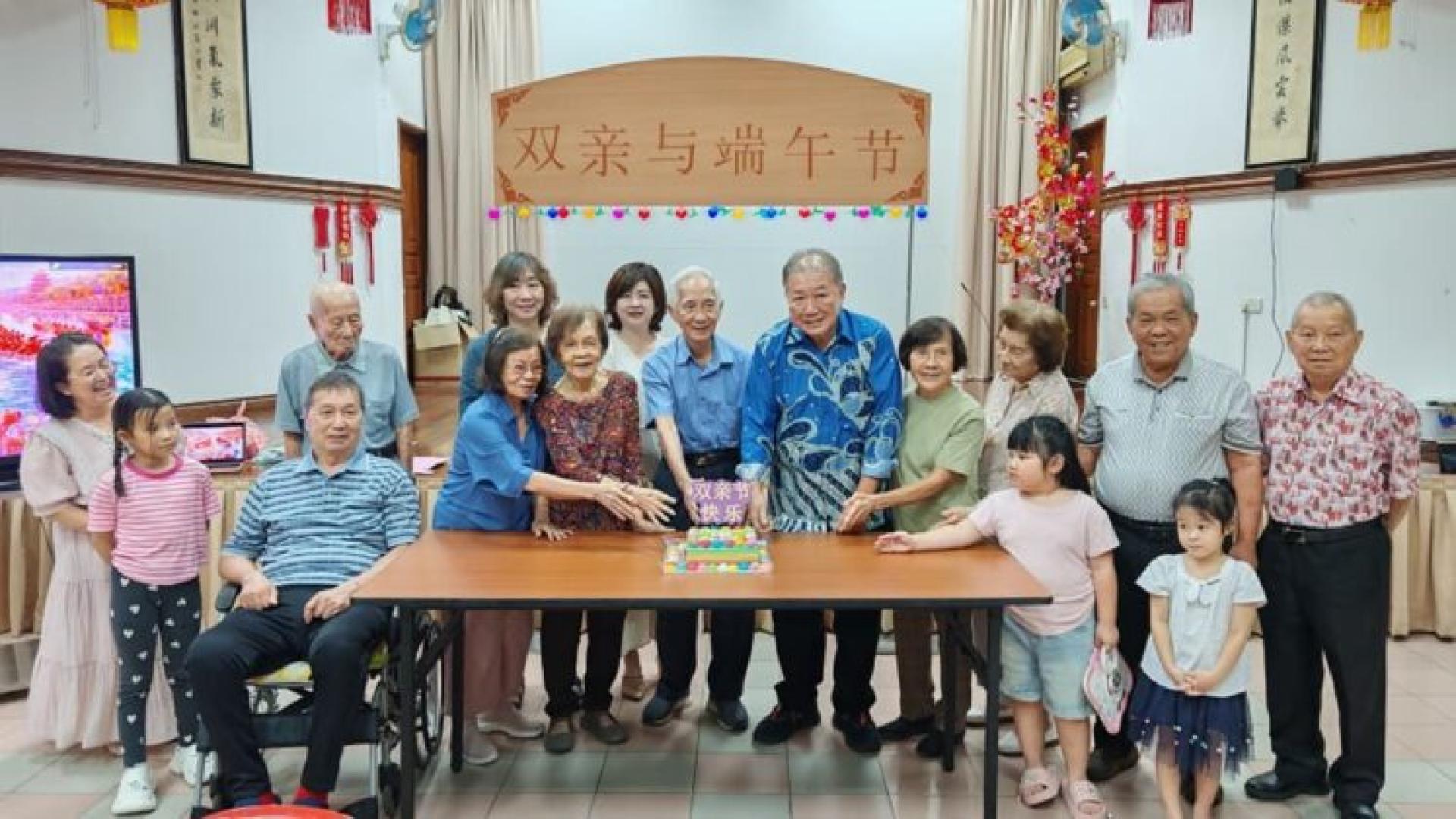 海南会馆主席韩煌光与年长者共切蛋糕
