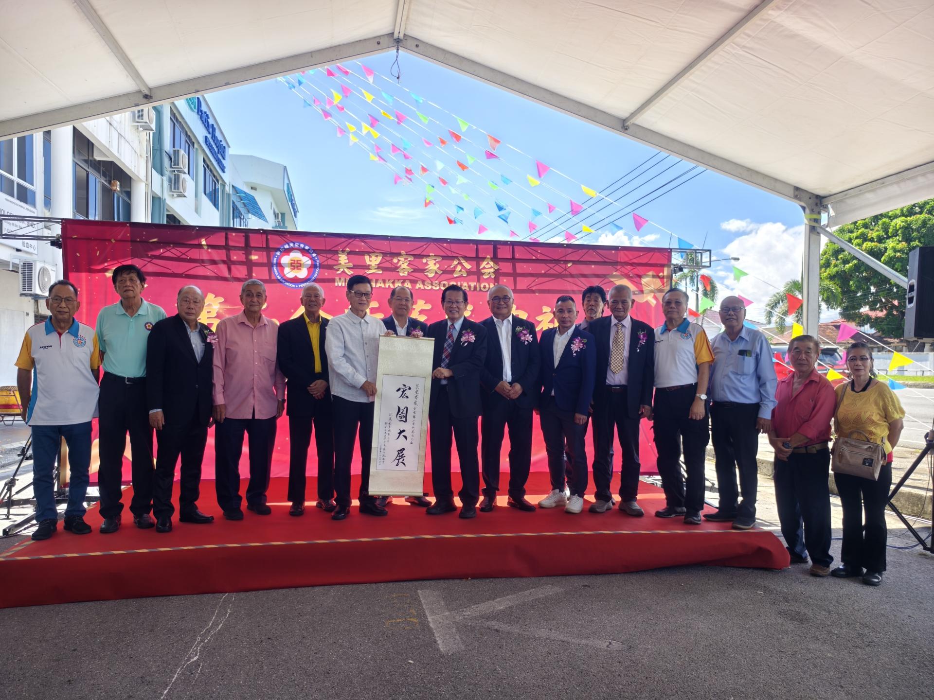 汶莱崇正客联总会创会长蔡仔运(左6)赠送墨宝予砂拉越交通部长亦是美里客家公会会长拿督斯里李景胜博士代收(右9)