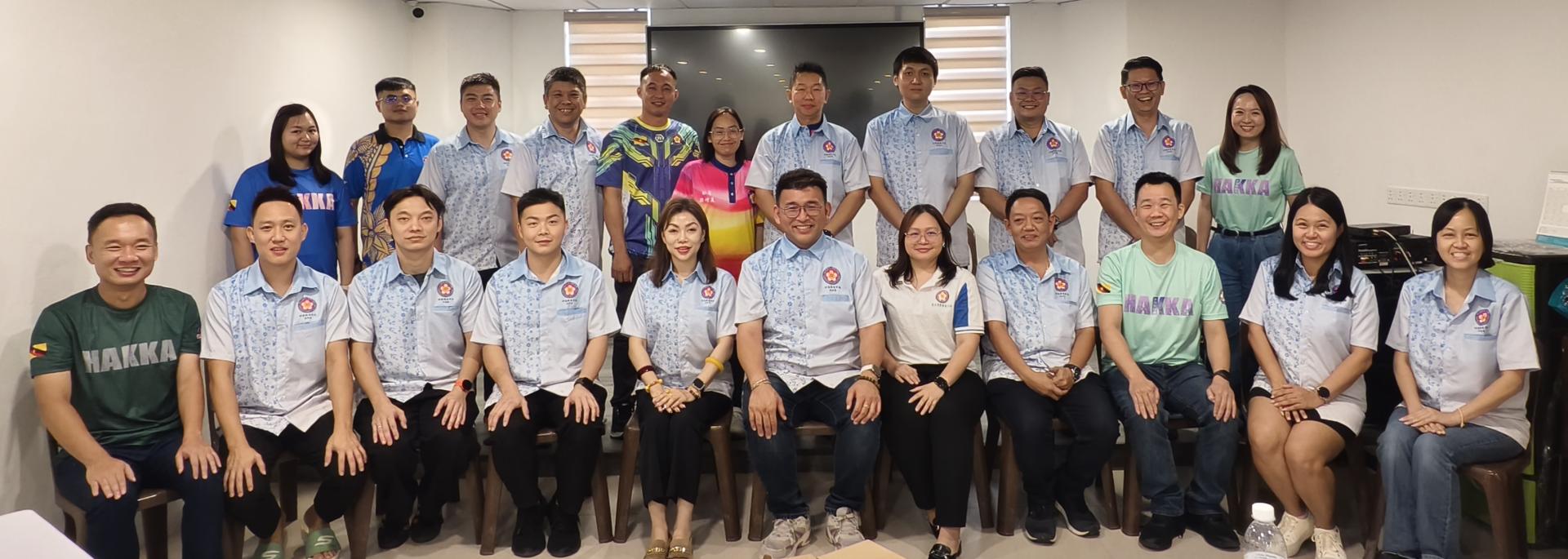 砂拉越客家公会联合会青年团第十二届第二次会议出席者合影。前排左起为副团长蔡伟杰、副团长梁明威、副团长刘哲贤、副团长刘子齐、署理团长李芳苇、团长陈政锖、副团长黄清萍、副团长赖坤和、副团长罗立翔、秘书刘丽美，以及财政刘丽珠。