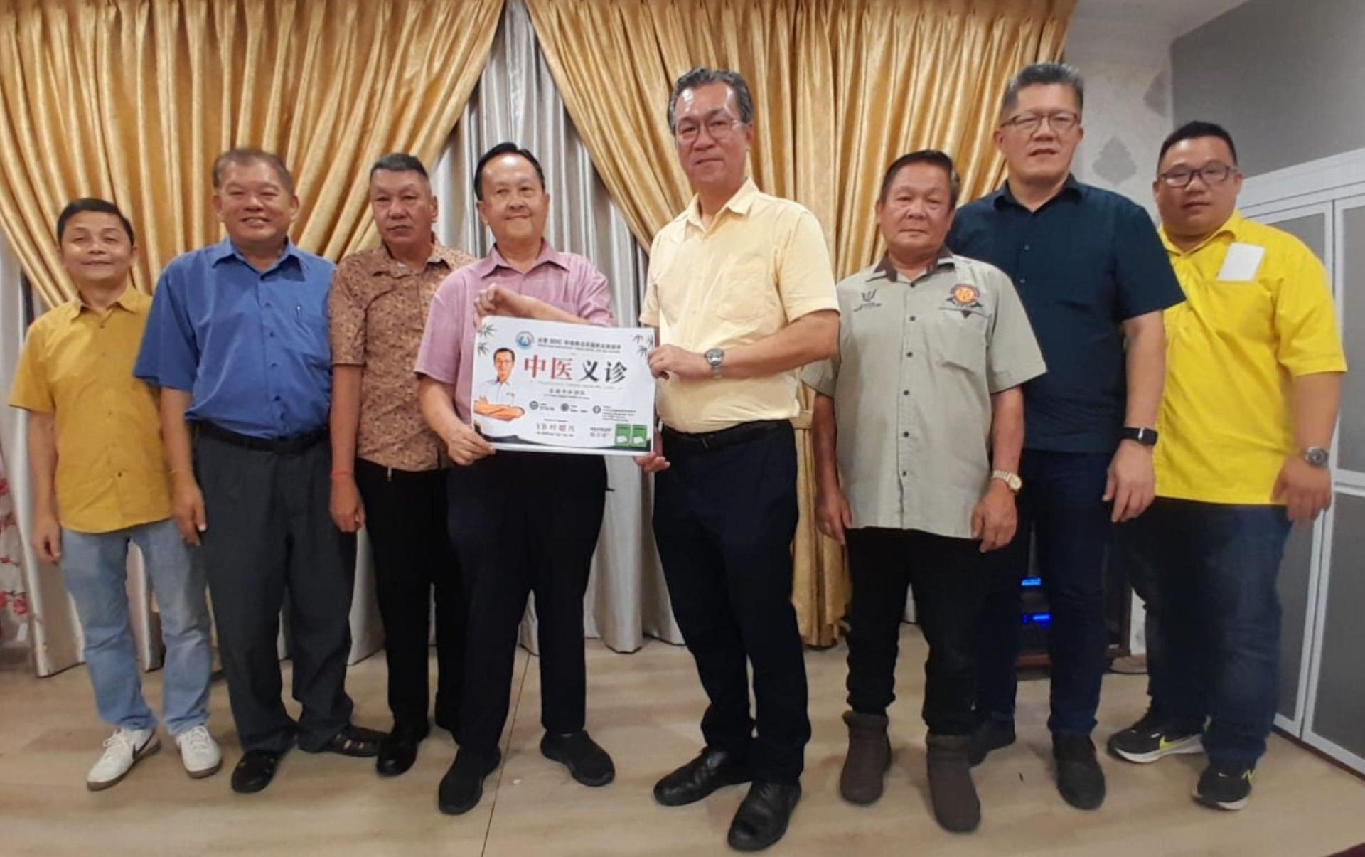 BDC砂地再也花园民众联谊会会长詹兴民（右4）移交中医义诊主宾函予叶耀星立法议员（左4）。左起为筹委主席龚世蝾市议员、本固鲁赖文麒、甲必丹温文明；右起是筹委江秀明、陈中兴中医师及何富强。