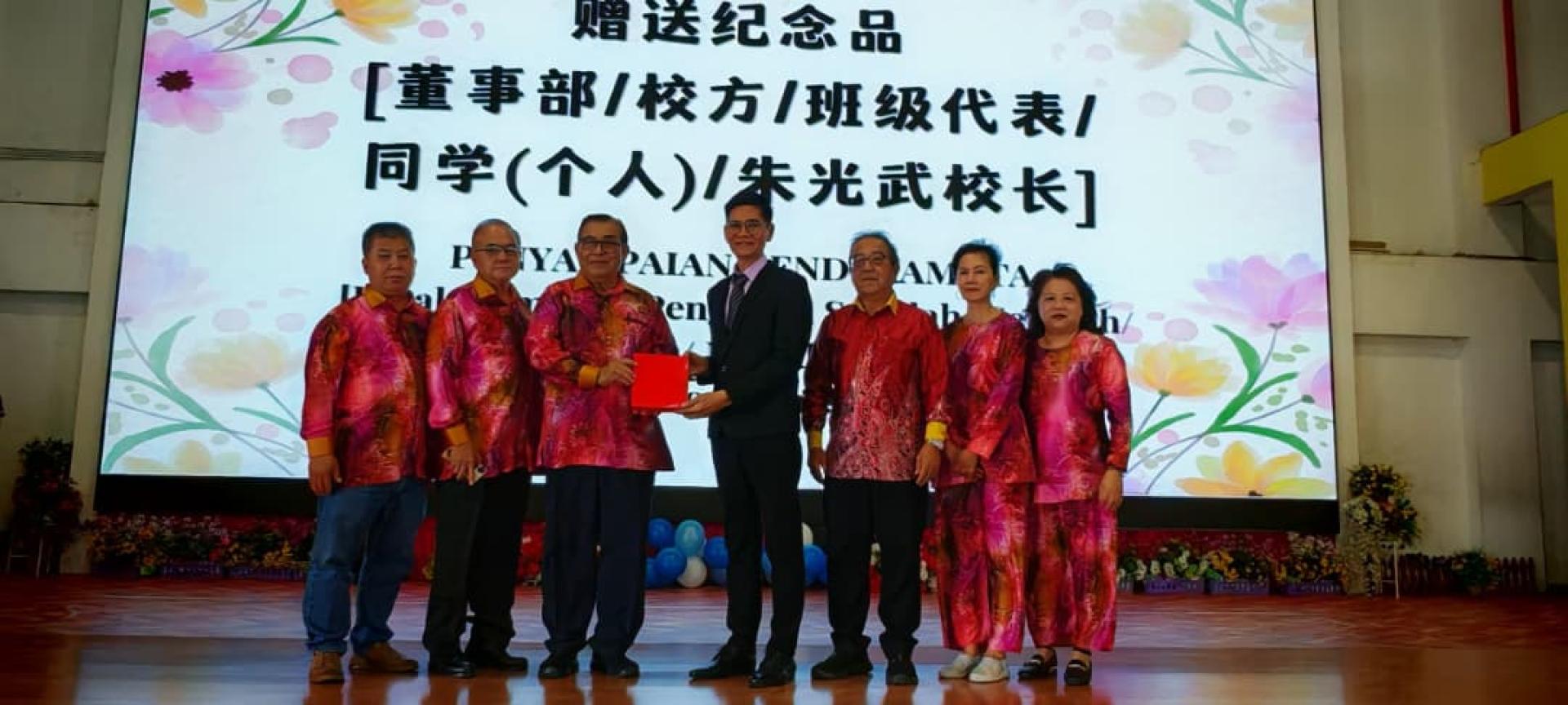 董事长本固鲁蔡刚明（左3）率领董事会成员赠送纪念品予荣休校长朱光武（右4），感谢其多年来对学校及华教事业的卓越贡献，并合影留念。