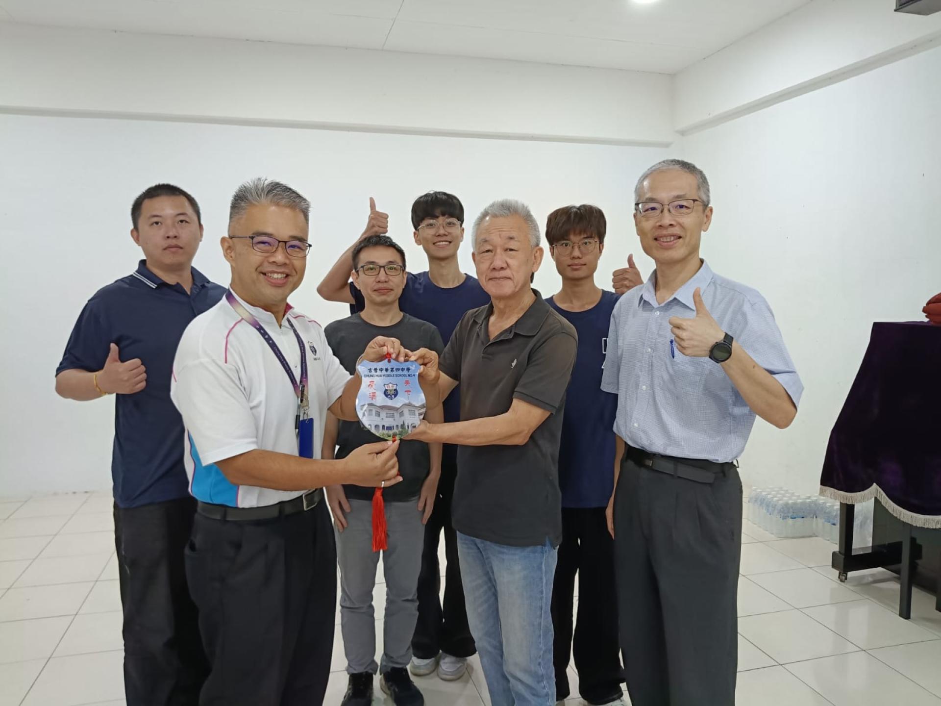 古晋四中校长官晨阳（左）赠送纪念品予国立台中科技大学副校长郑经伟博士（右），感谢台中科大师长团远道而来分享专业知识。陪同者包括国际长连俊玮博士、赖嘉均教授及李承翰教授。