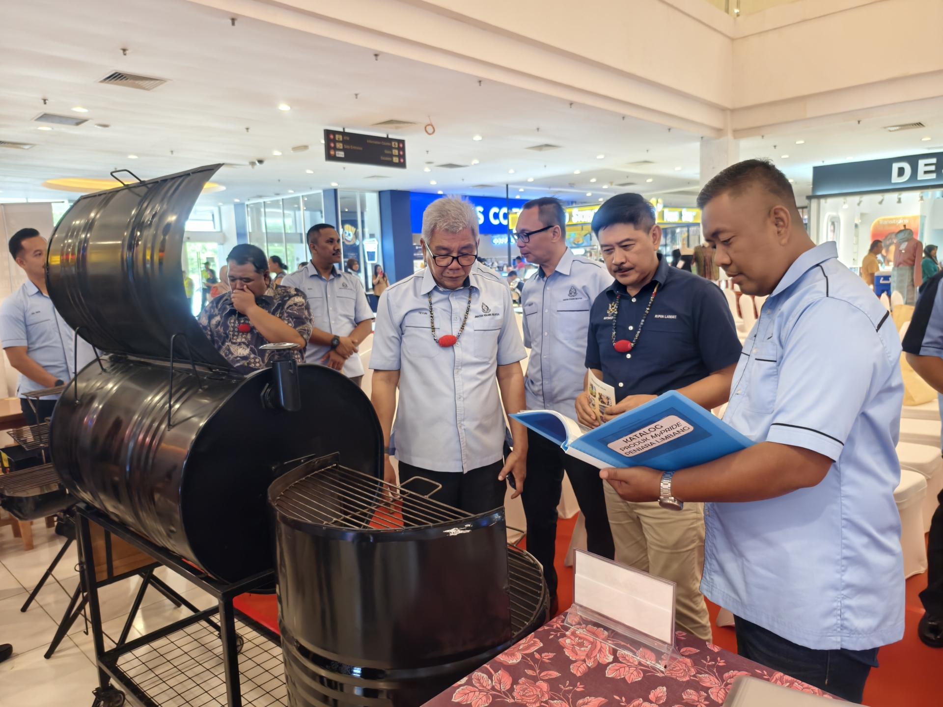 嘉宾参观大马监狱局自强展销会展位，了解技能培训成果。右2为砂拉越企业家发展部副部长拿督立宾拉曼。
