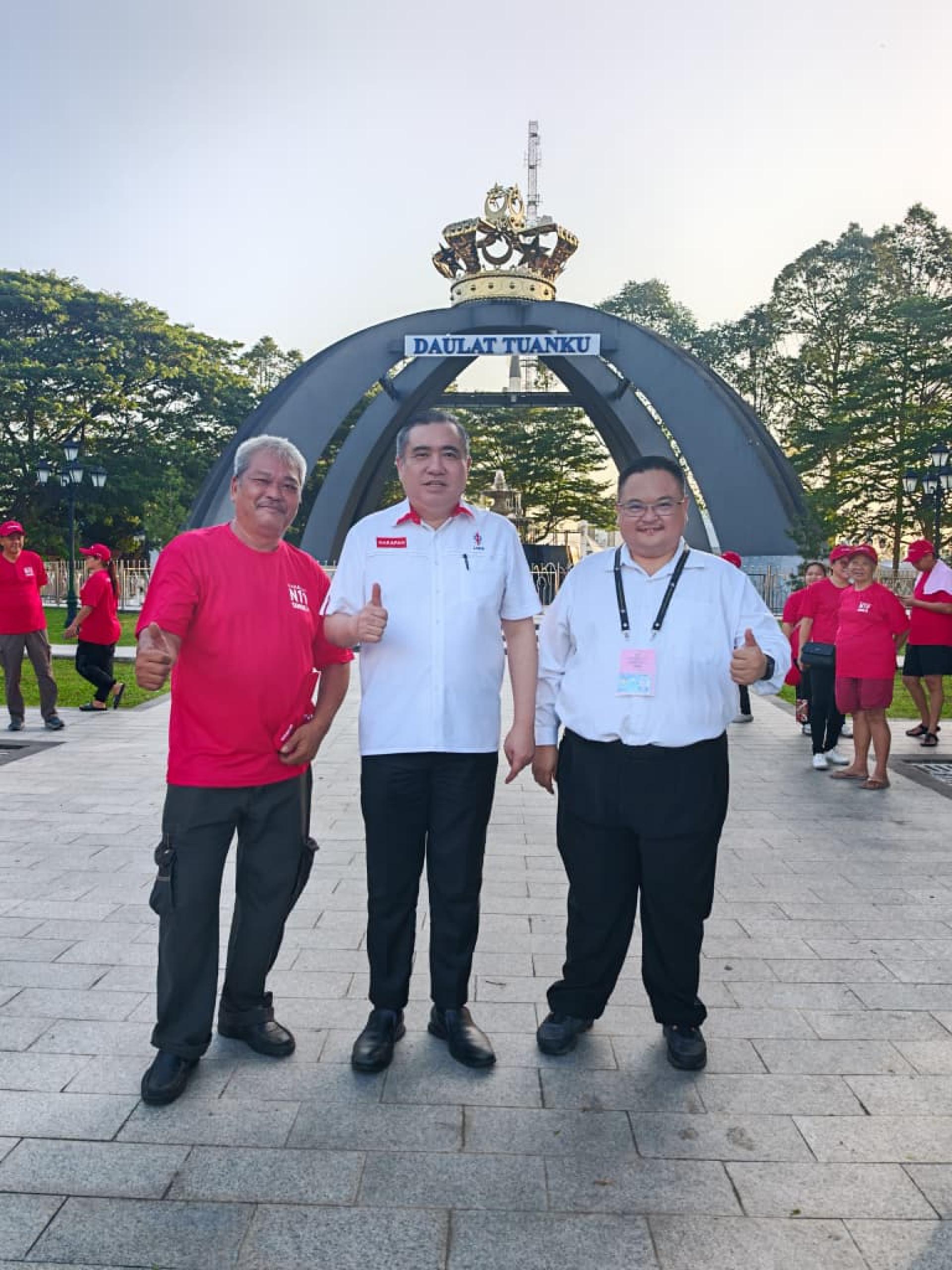 行动党秘书长陆兆福（中）与东甲候选人黄俊历（右），在提名中心外合照。