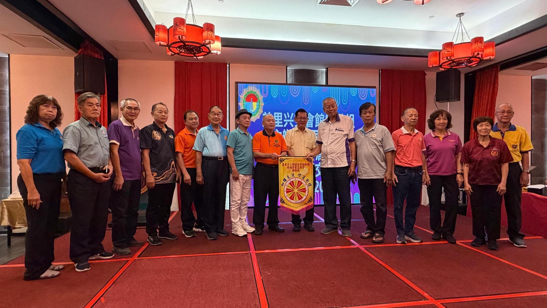 美里兴安会馆乐龄组主任陈国荣（左8）赠送纪念锦旗予拿督斯里李景胜。
