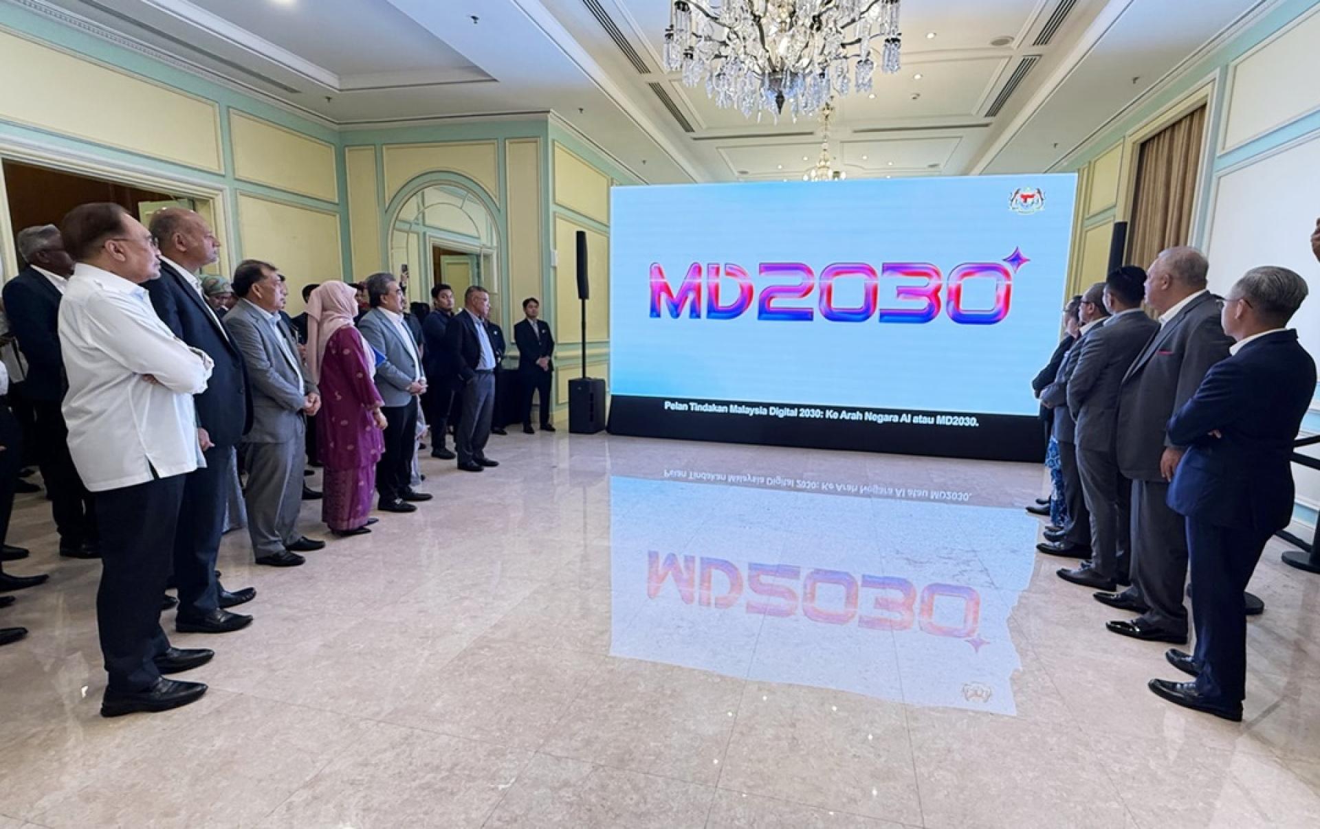 安华（左）在布城首相署大楼观看“2030年马来西亚数码”（MD2030）行动计划”的推介视频。
