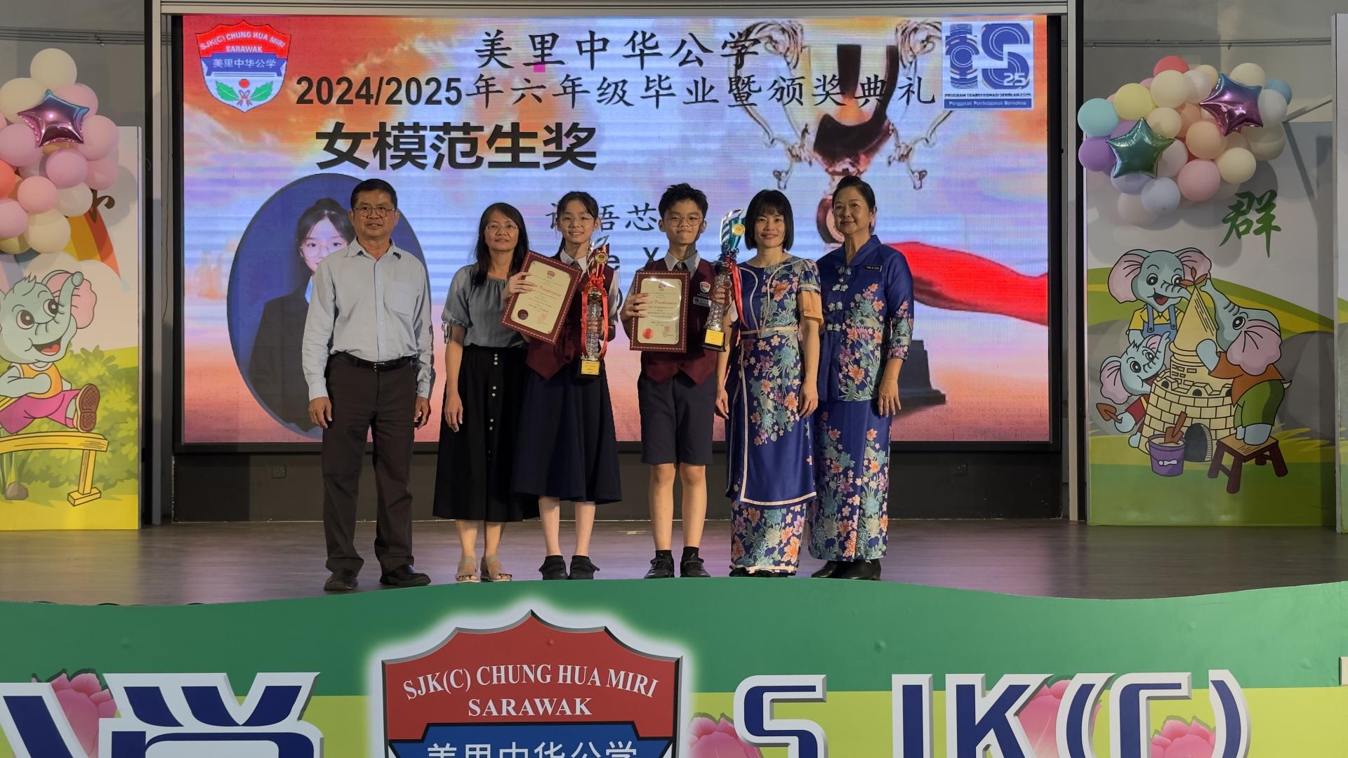 获得年席男女模范生奖的黄永轩（右3）与许语芯（左3）以及家长合影于领奖后。左1为董事长李开运、右1为校长陈泳伽。