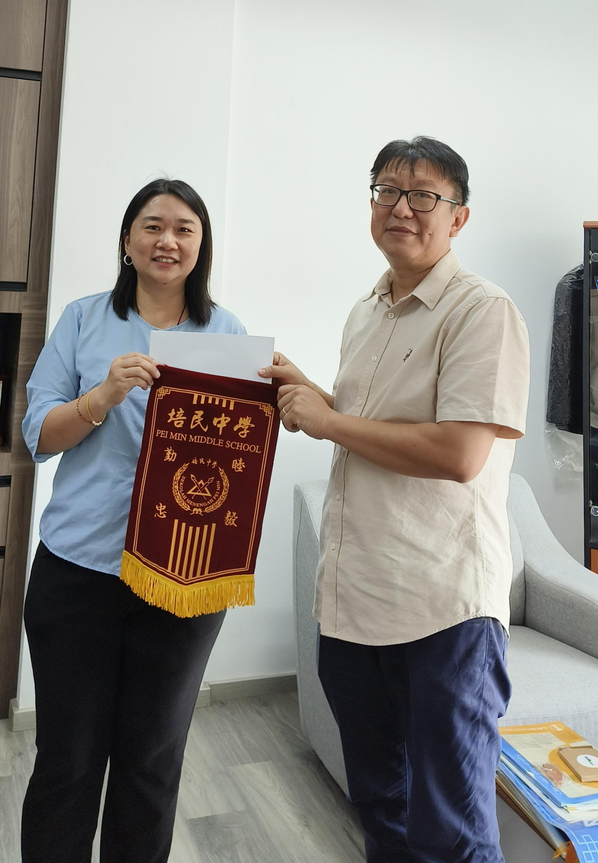 美里乐购城（My Mall）经理郭溢恩（右）移交华语辩论比赛活动经费予培中校长贝美娇（左）。