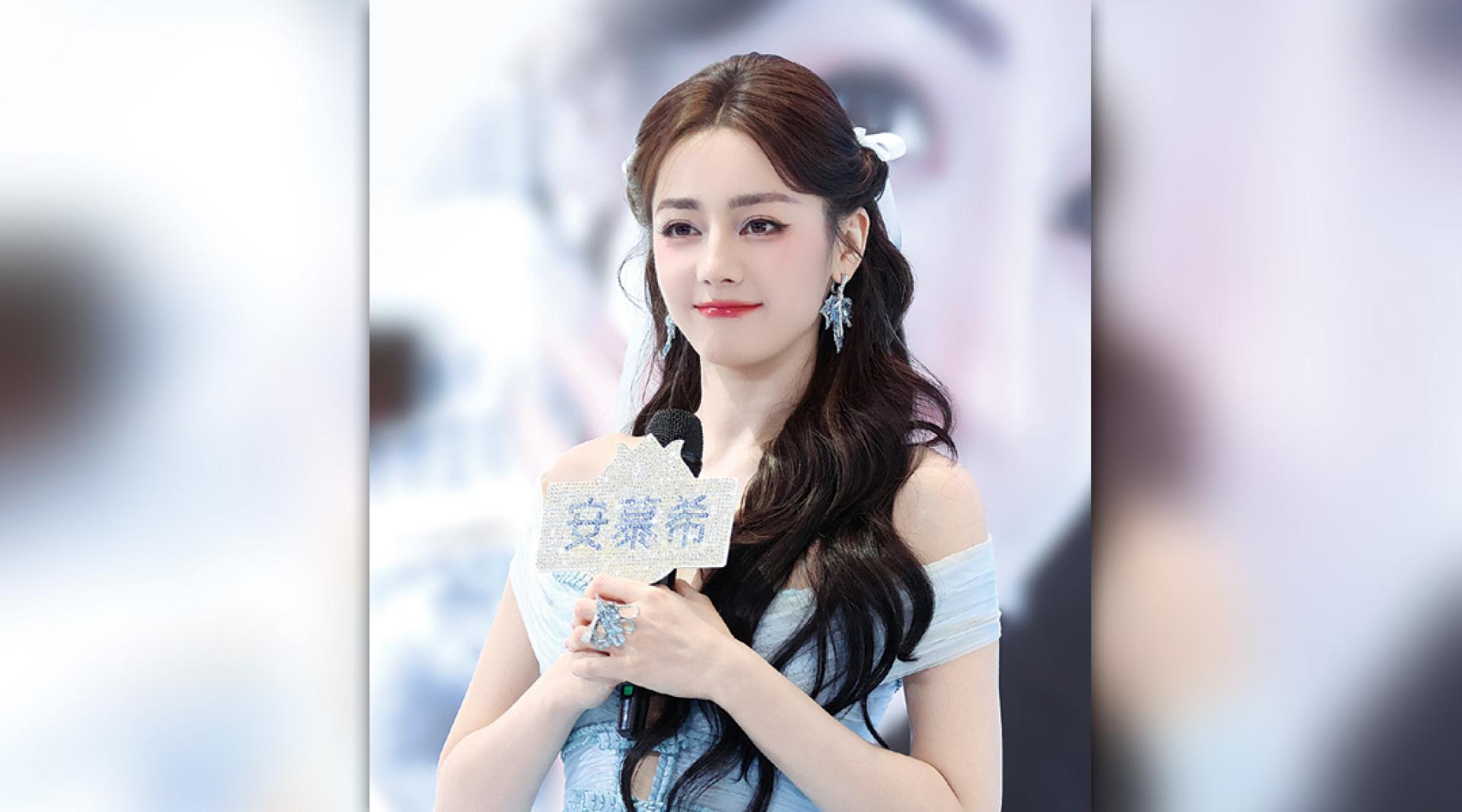 迪丽热巴出席活动，全程拿麦克风、长发挡住胸口防走光。