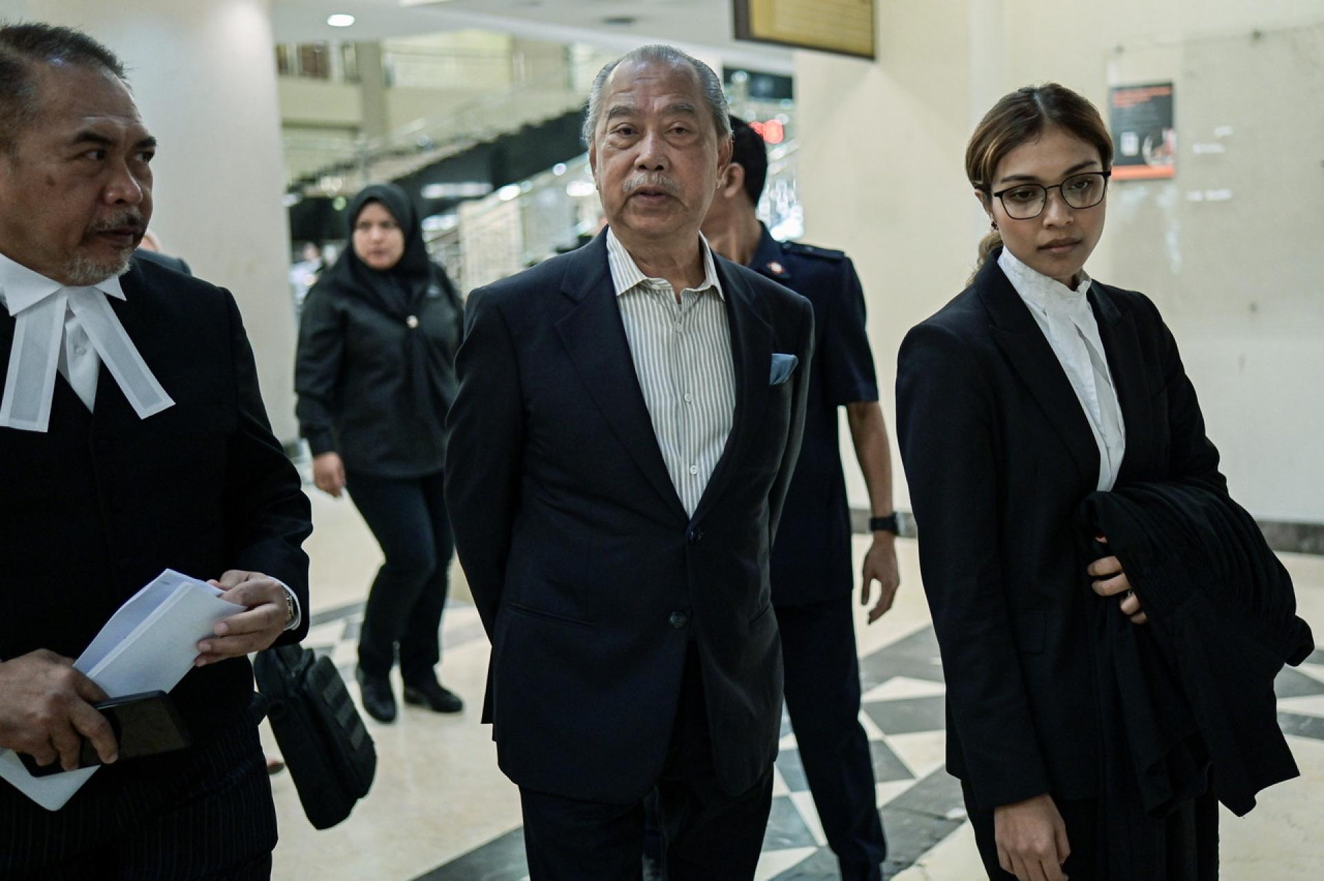 慕尤丁（中）在律师陪同下出庭，听审他涉及的Jana Wibawa7项洗黑钱和滥权控罪弊案的审讯。