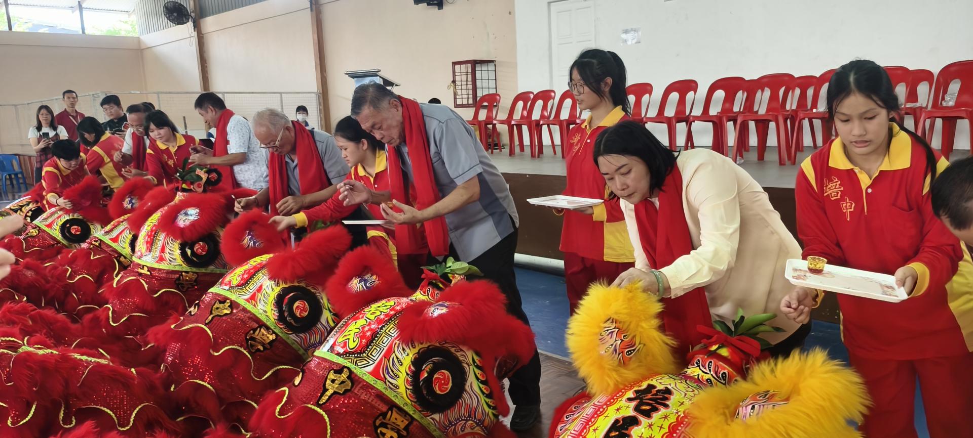 左起为校长贝美娇，培民中学董事长许为隆，副董事长黄新漳等，为新狮进行点睛。