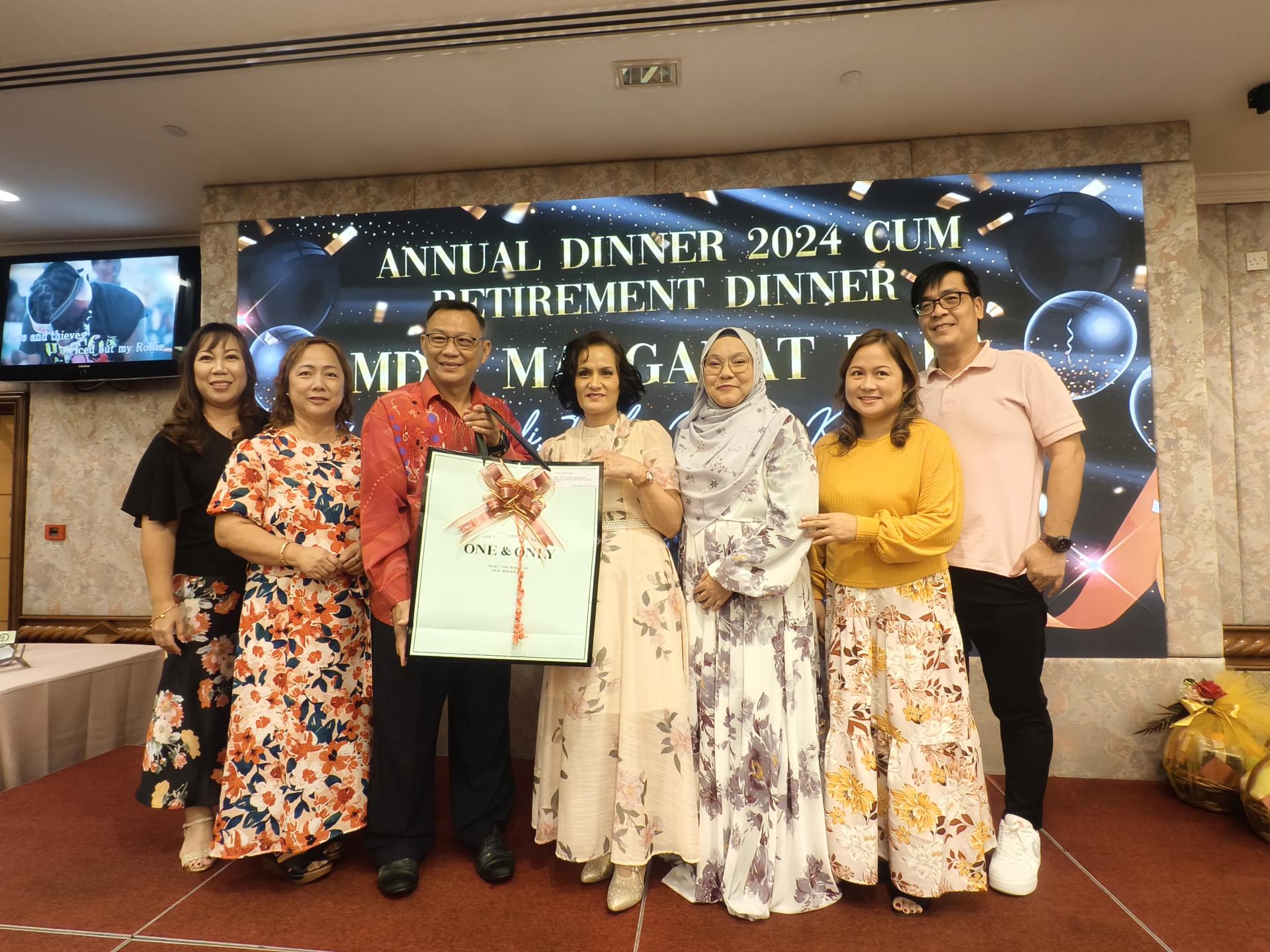 美里圣约瑟小学家教协会主席吴祀盛(左3)在年宴兼荣休欢送会上，赠送纪念品给玛格拉巴拉老师。