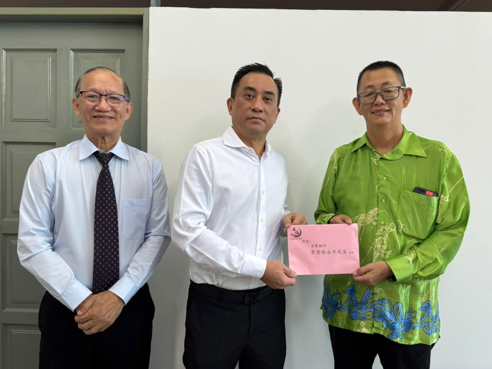红狼传媒与文化董事长兼筹委会主席杨镇声移交邀请函予名誉顾问拿督张永平，左为副主席包平生。