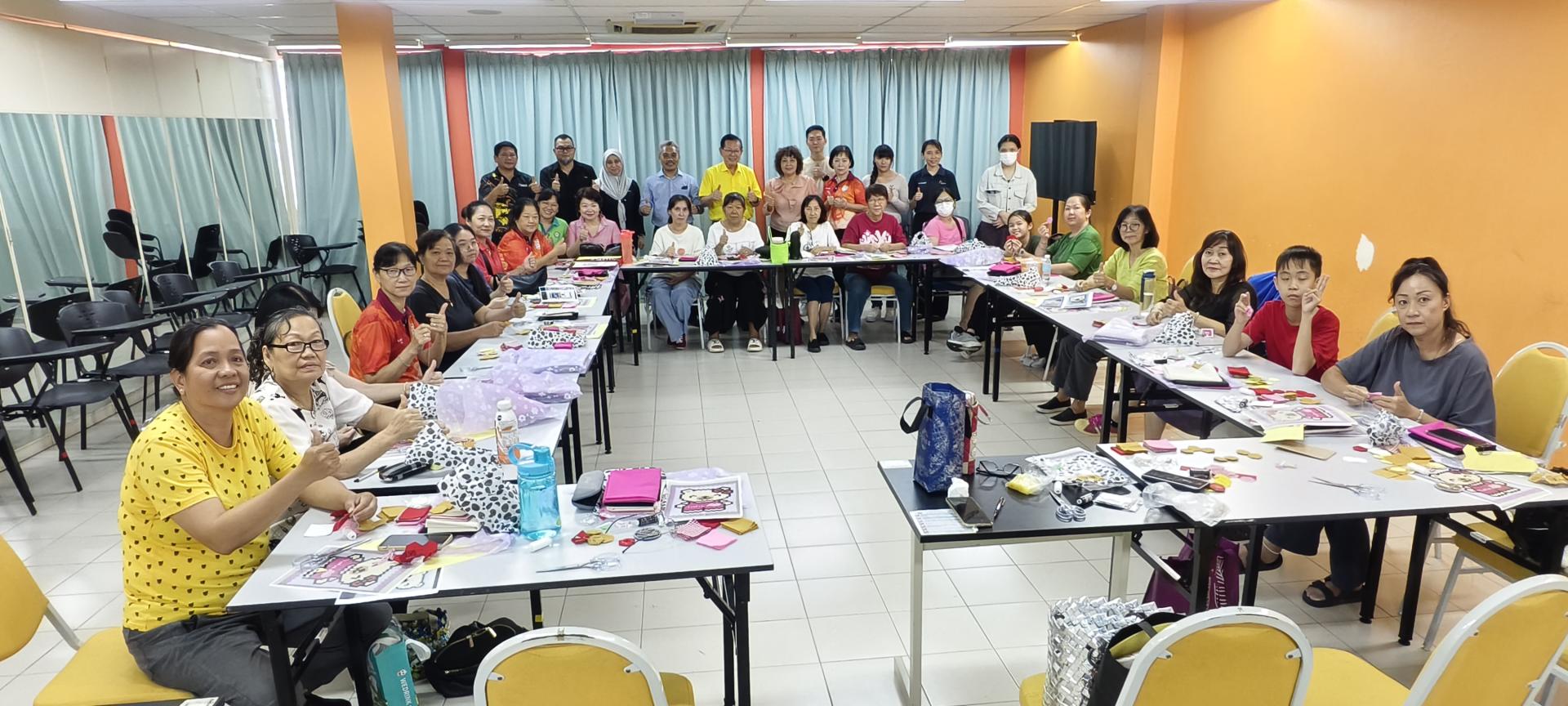 拿督斯里李景胜（后排中者）与参加“百家被基础学习班”的学员亲切交流并合影留念。左4为美里社区学院院长哈曼慕达，左6为美里单亲妈妈咨询中心主席甲必丹郑敦明。