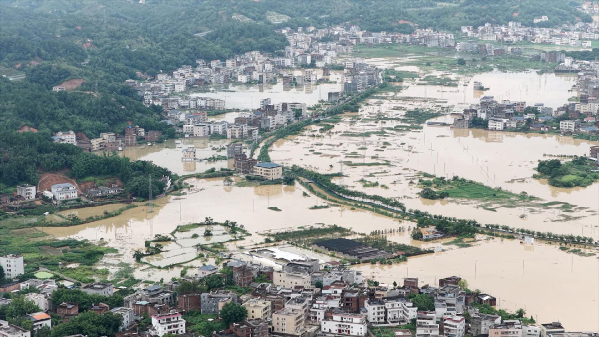 7月27日，受台风“红霞”影响，广东梅州五华县强降雨持续，河流水位急剧攀升，多处河段出现河水漫溢、村庄严重内涝，低洼区域民居被积水围困。（圖：中新社）