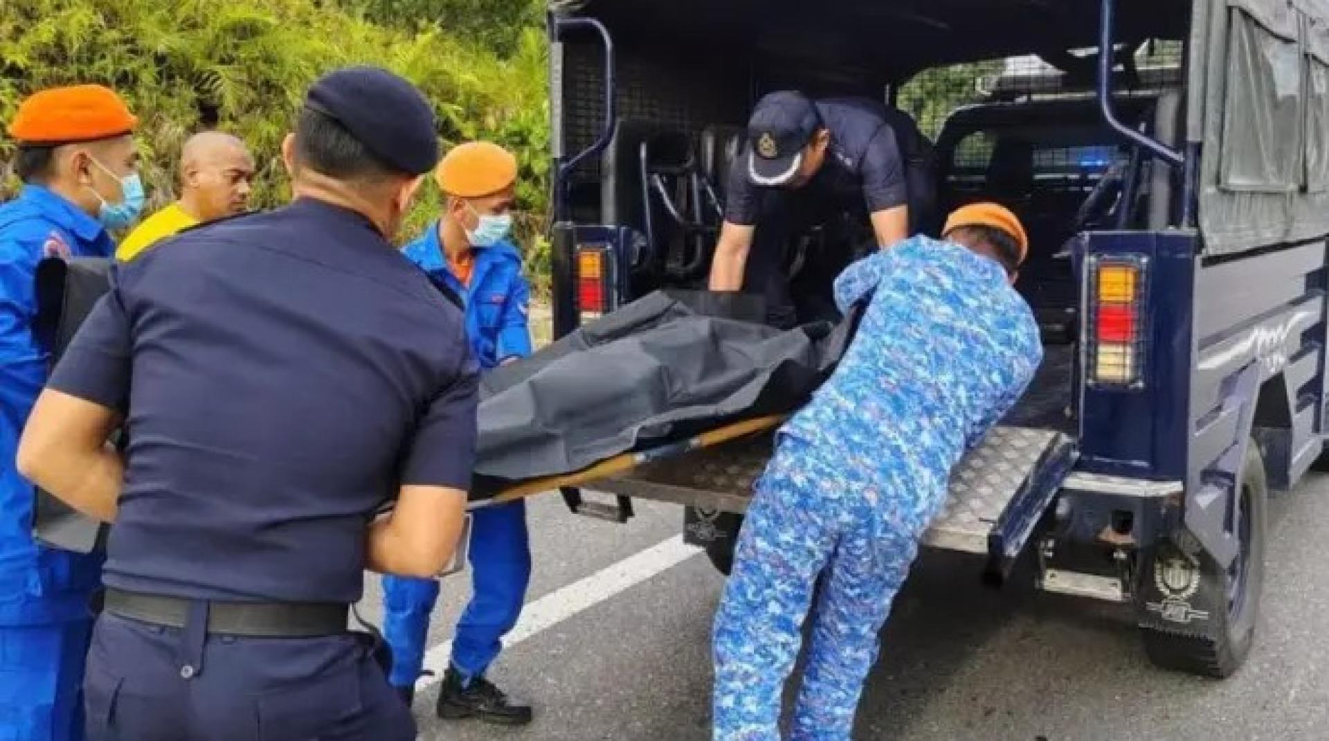 安全人员在泛婆大道民都鲁-诗巫路段第83公里处发生致命车祸后，搬移死者遗体并将其移送至警方车辆。（图：沐胶警区总部）