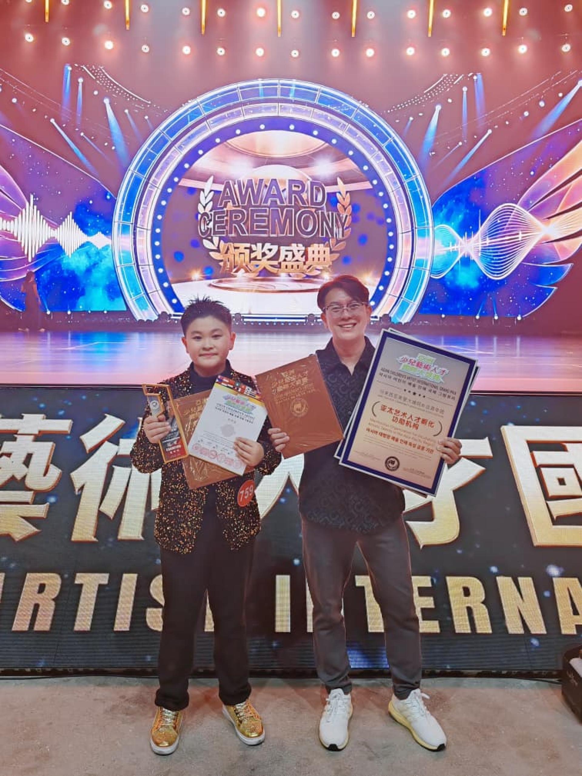 右起荣获年度杰出指导老师奖的东马海选授权导师朱景祥与来自民都鲁总冠军得主钱伟成合照。