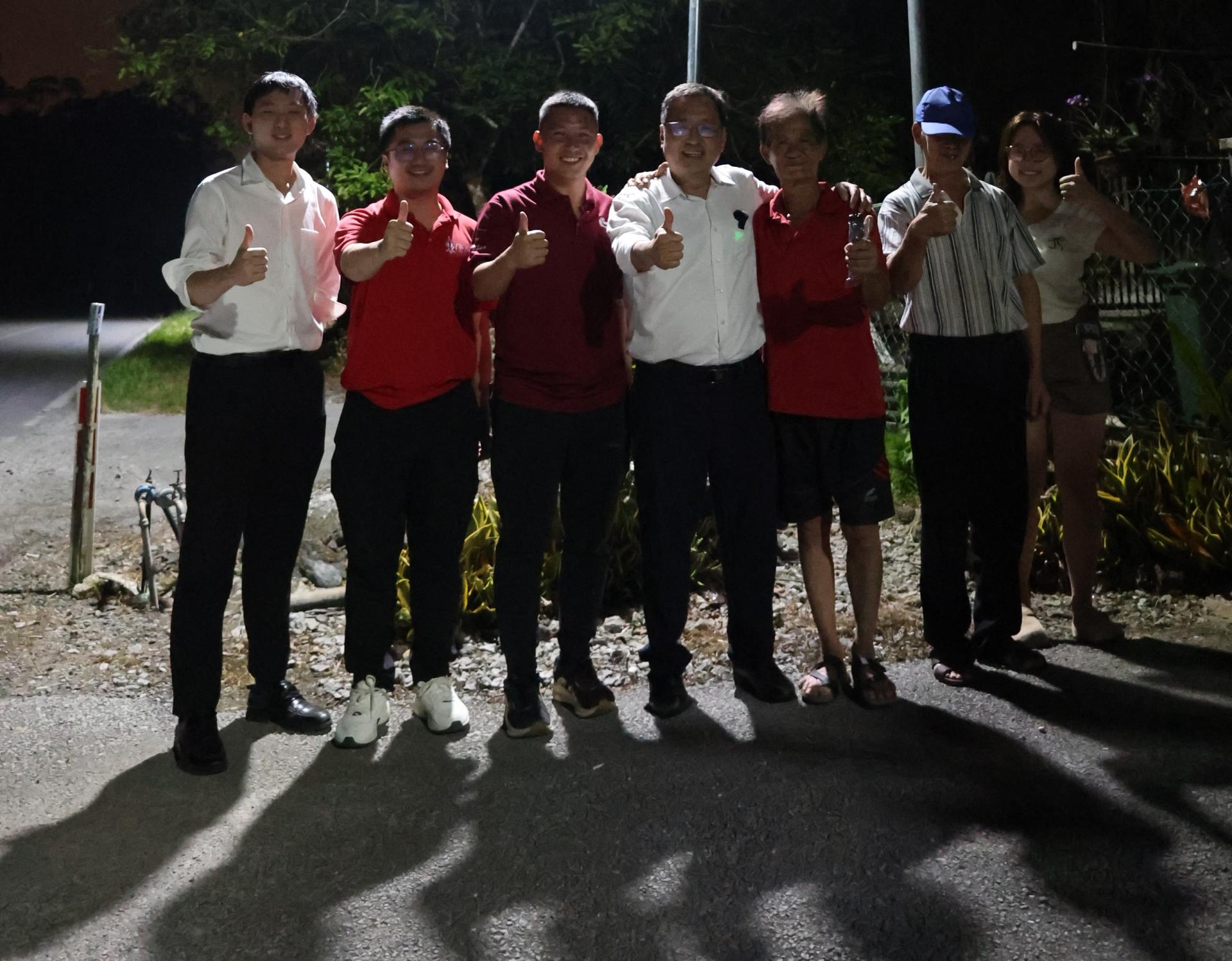 砂行动党实旦宾区国会议员张健仁（中）日前夜晚亲赴石角区味源港沙加路验收‘装路灯，点亮石角’计划的成效，与居民们一同攒好。左起为张健仁之子张翰贤律师、张健仁特别助理苏天仁及沈杰龙。