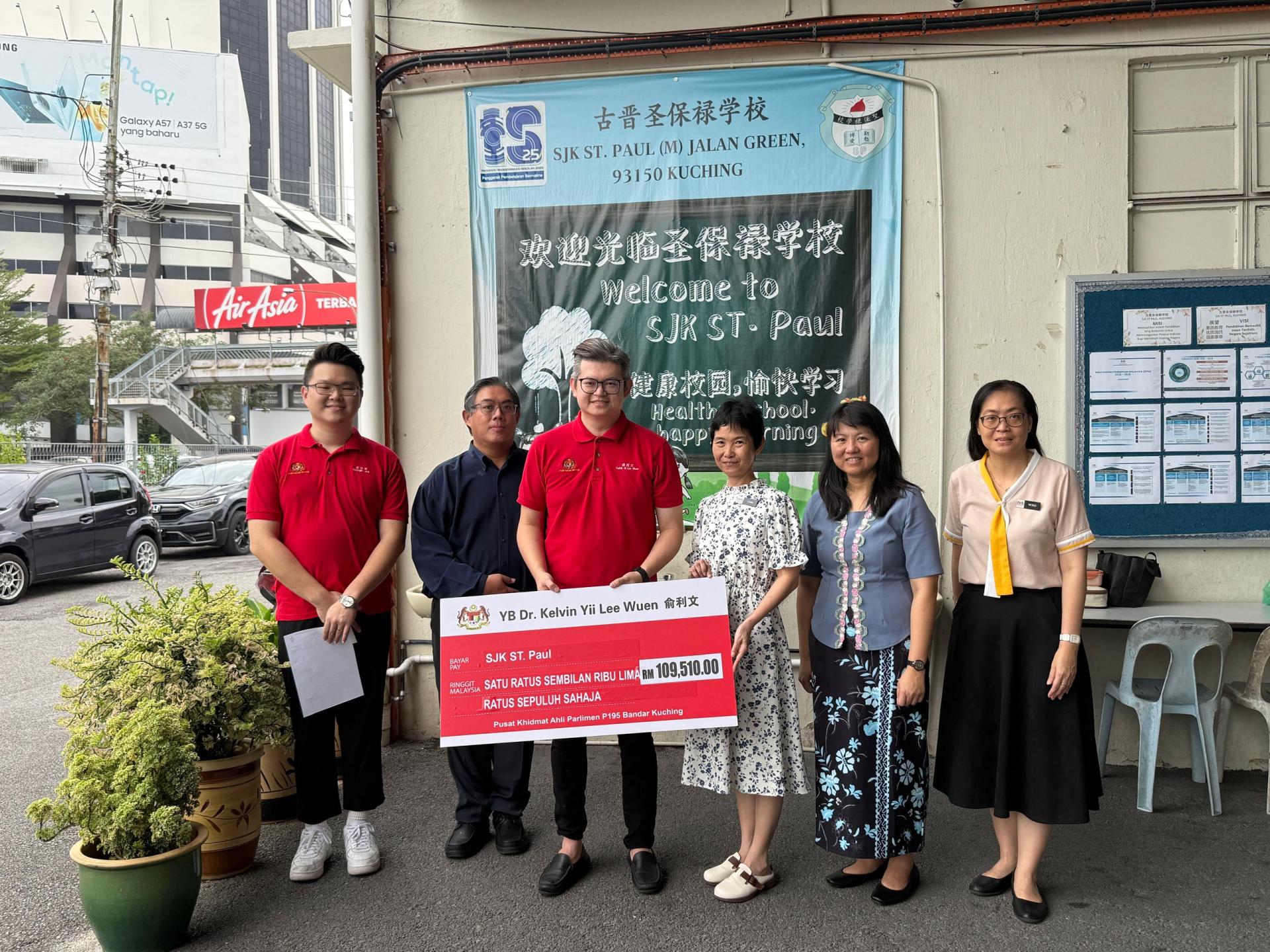 古晋市国会议员俞利文（左3）移交10万9510令吉拨款予圣保禄学校，用于添购全新办公设备及提升学校各项设施所需。