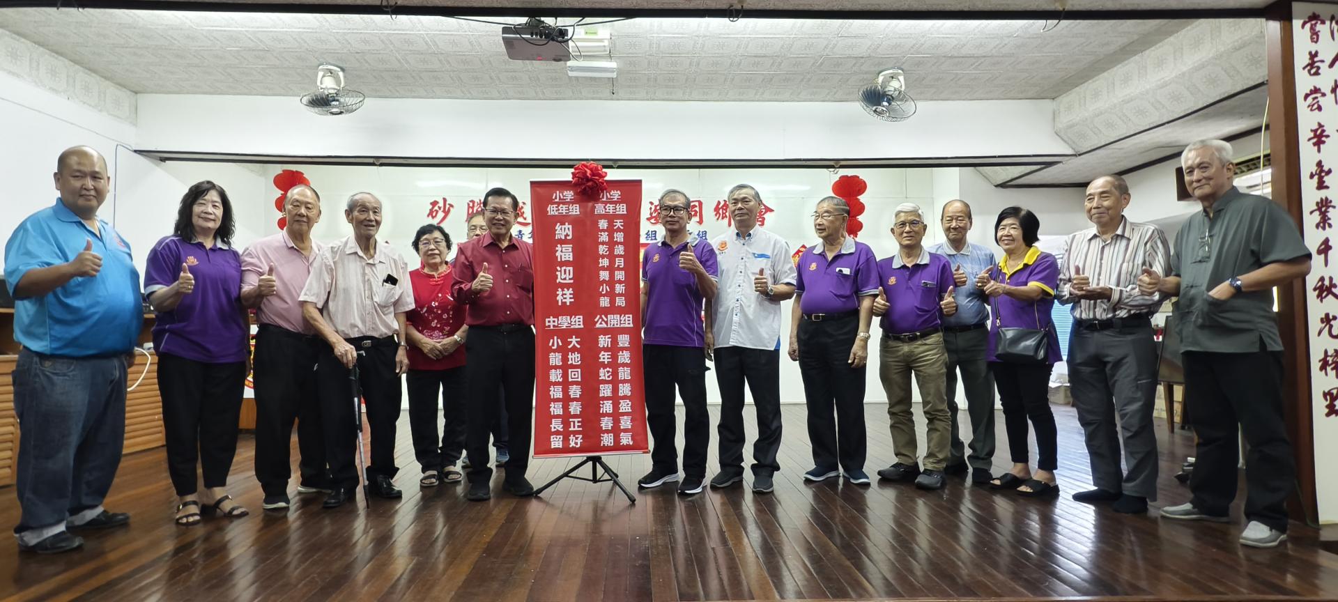 砂交通部长拿督斯里李景胜在众人陪同下，为挥春比赛主持揭封仪式合影。