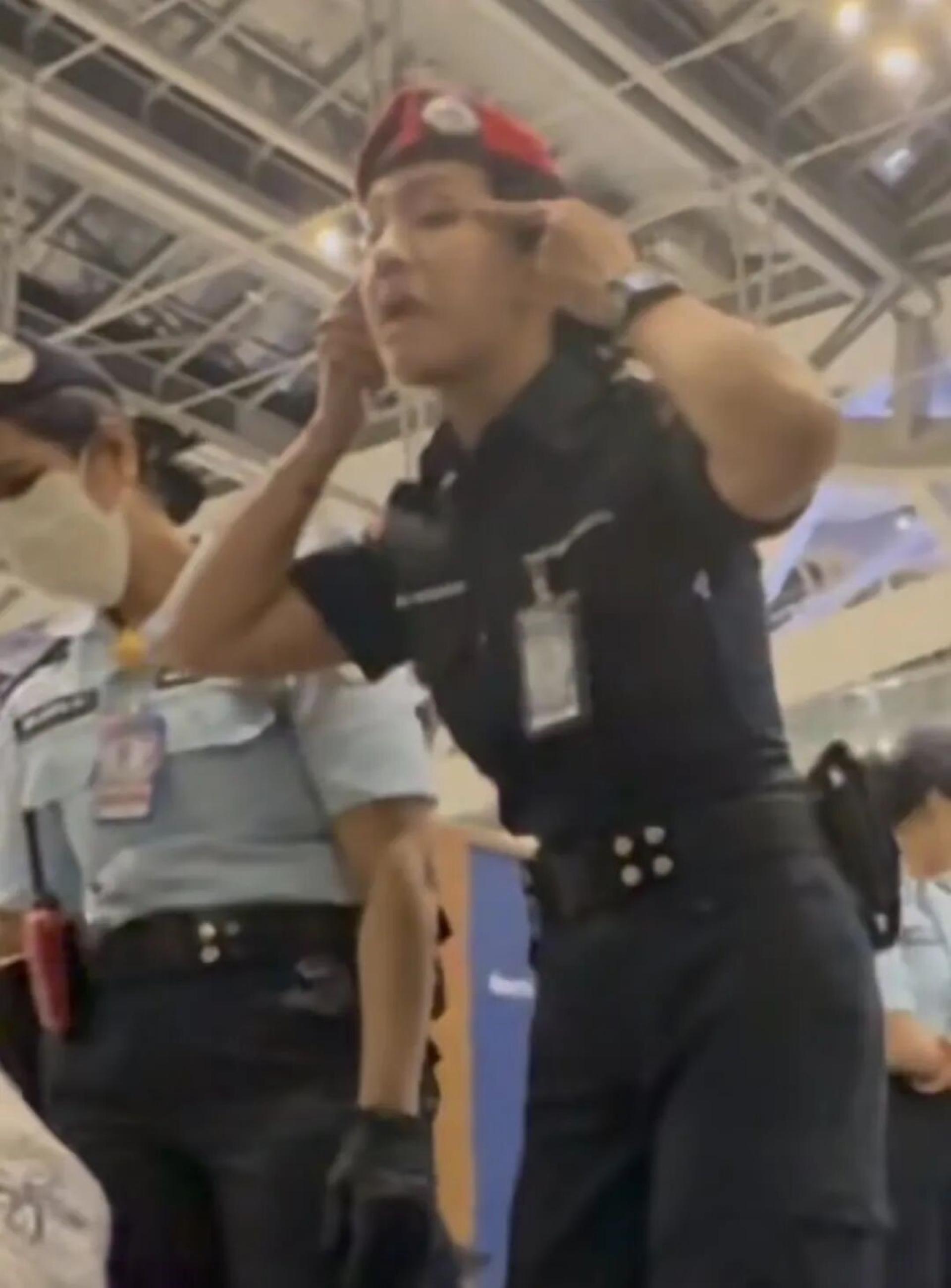 更引发争议的是，一段现场视频显示，一名身穿安保制服的人员疑似朝中国乘客做出拉扯眼角的动作，被质疑带有歧视意味。（网传视频截图）