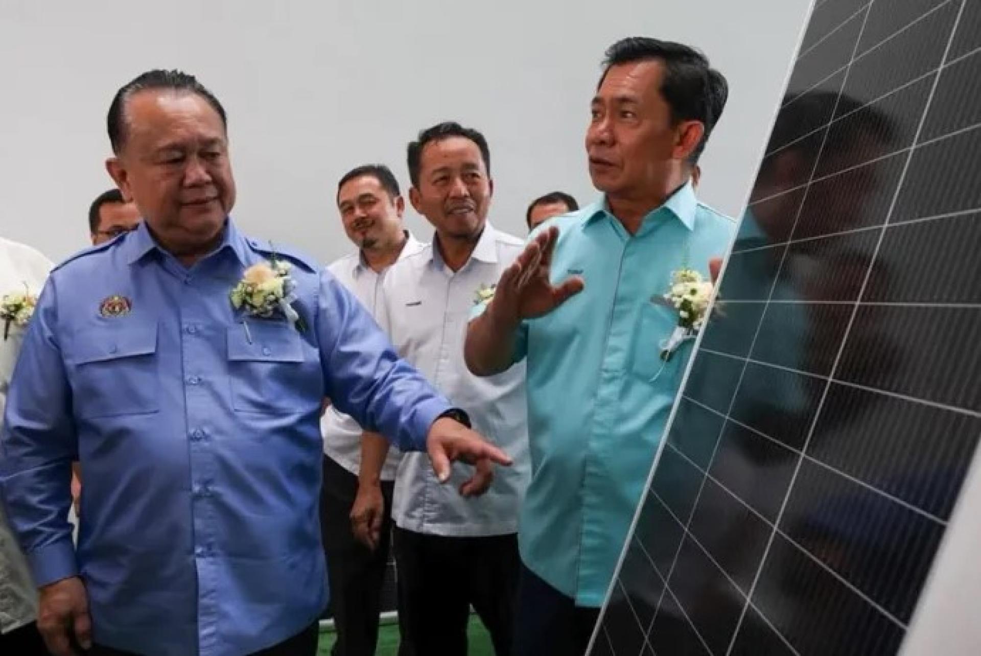 南达（左）于2026年8月10日参观巴生SBC Lighting私人有限公司期间，检查为LED路灯提供电力的太阳能板。