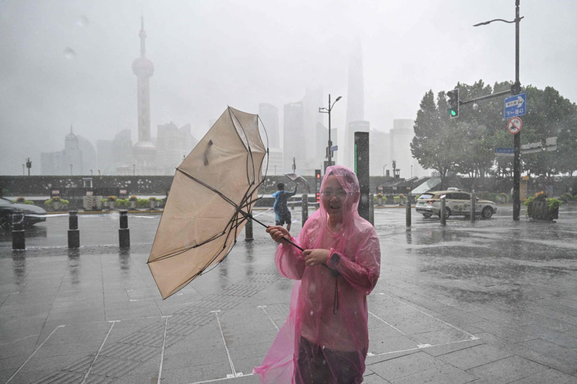 上海一名路人伫立在暴风雨中。