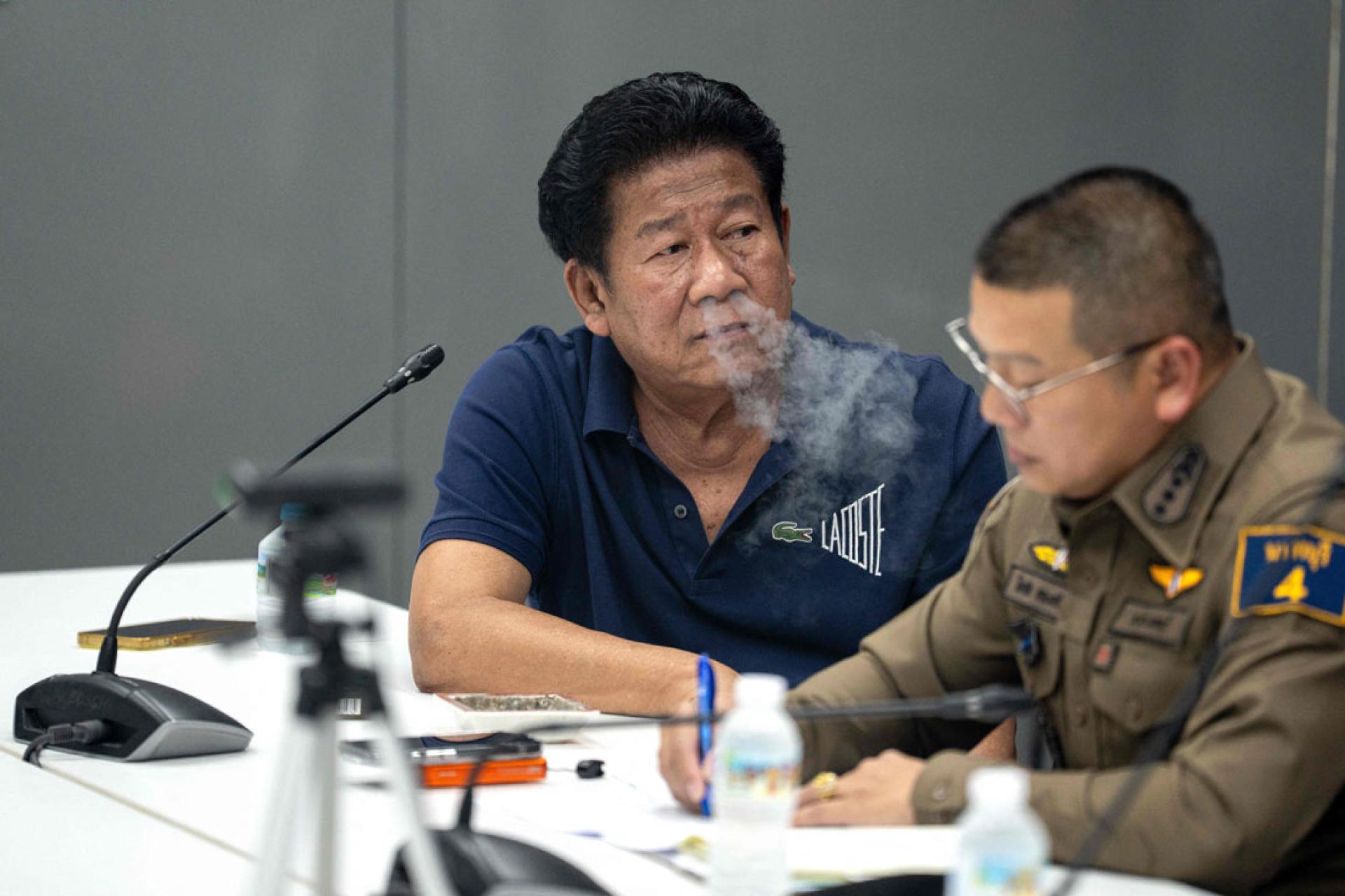 查隆被捕后获准在警察局举行记者会，一边抽烟一边说着事发经过。