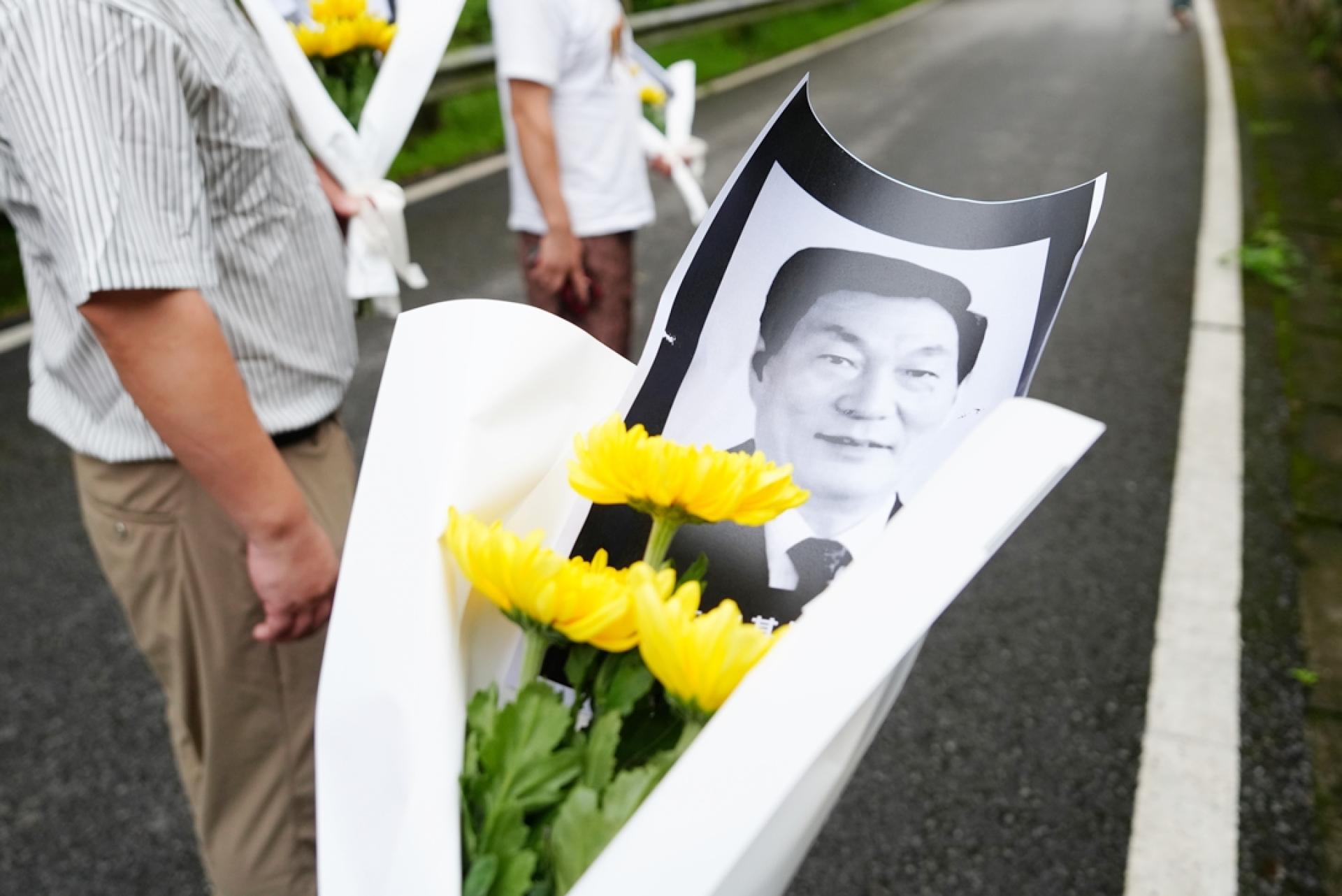 民众手持鲜花来到湖南省长沙县安沙镇和平村棠坡恬园悼念朱镕基。（图：中新社）