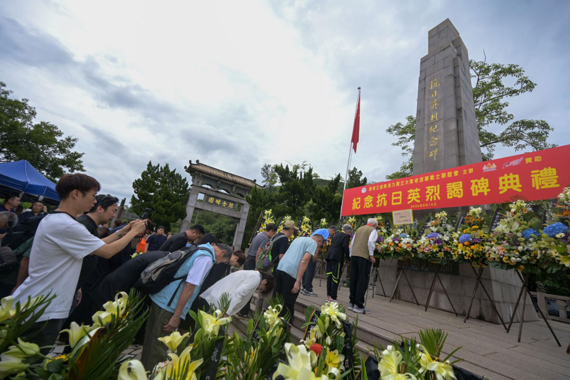 8月15日，原东江纵队港九独立大队老游击战士联谊会在香港西贡斩竹湾抗日英烈纪念碑园举行谒碑仪式，悼念于1941年至1945年香港沦陷期间为保卫香港而捐躯的人士。图为嘉宾向纪念碑鞠躬。