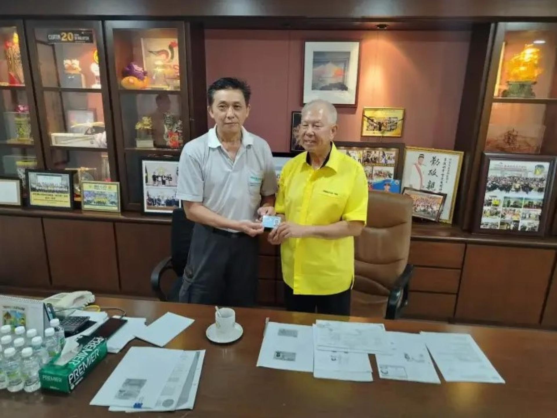 杨昌雄（左）于8月17日在砂人联党第73届埔奕支部服务中心举行新闻发布会后，从拿督陈超耀（右）手中接领大马卡。图：砂拉越公共通讯单位（UKAS）