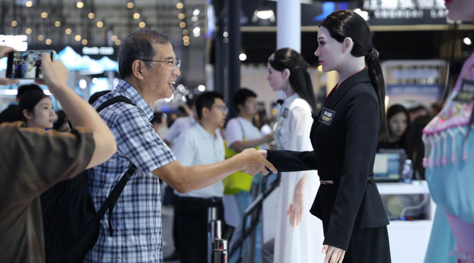 2026世界机器人大会参观者与迎宾机器人互动。