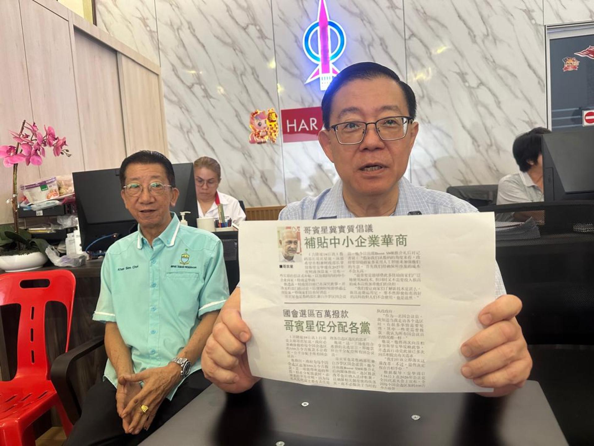 林冠英（右）展示哥宾星为中小型企业发声报道，并揶揄相关部门官员在“睡觉”。