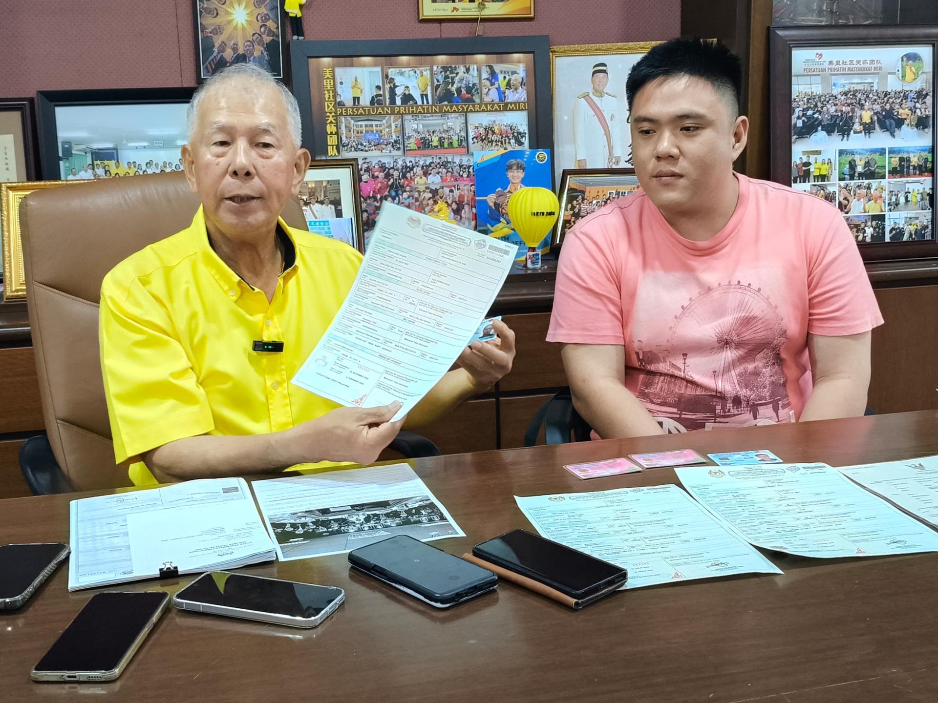左起砂旅游部副部长拿督陈超耀及吴志康，展示吴志康妻子及两名孩子领取的大马卡。