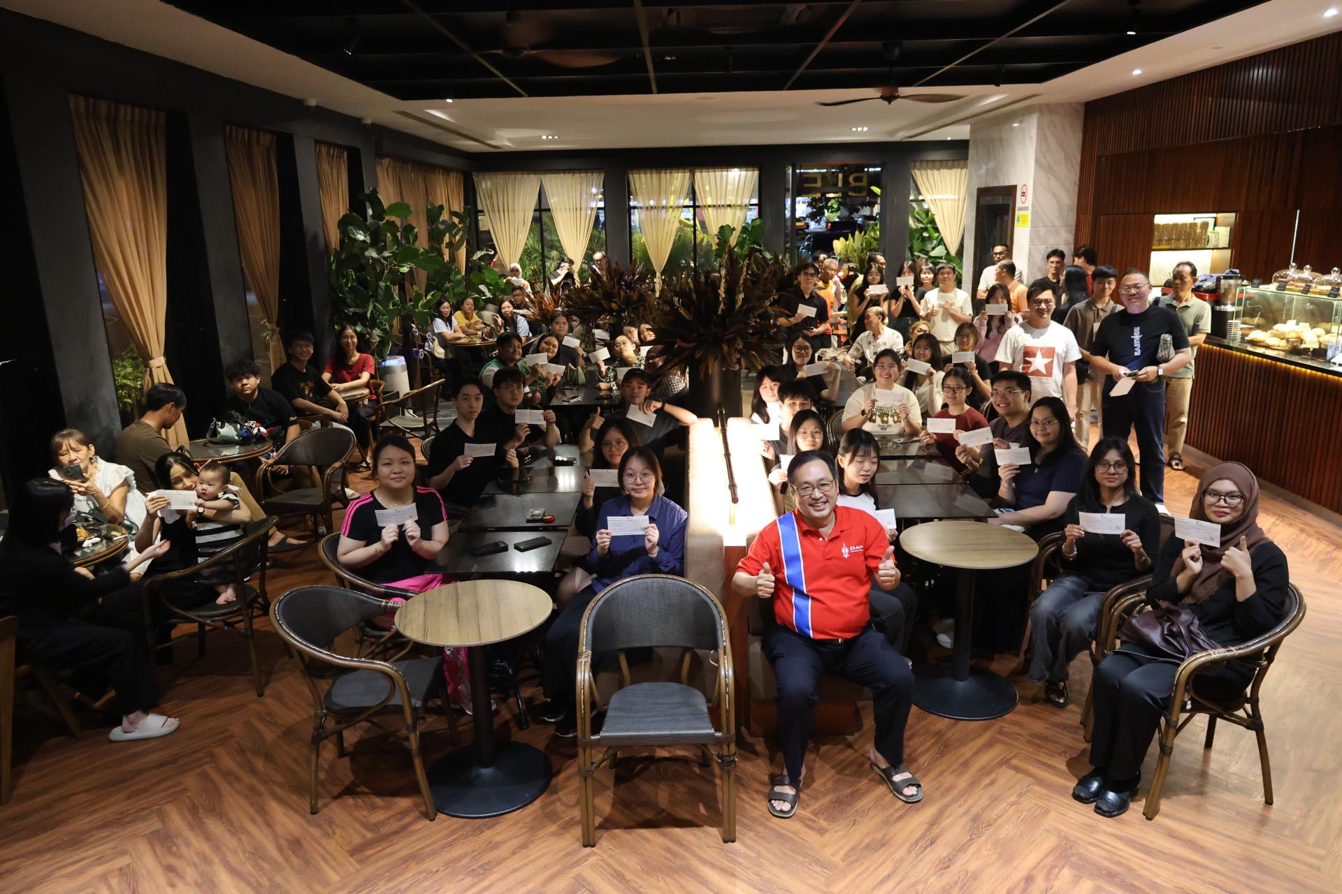 所有得奖的学子展示其支票，喜悦地与砂行动党实旦宾区国会议员张健仁（前中）合影。