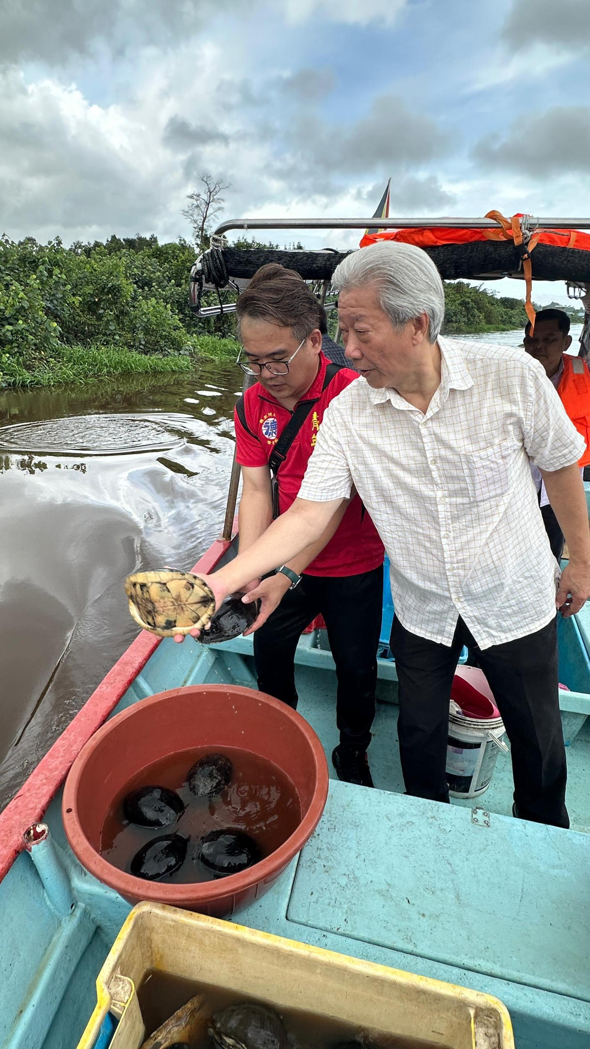 美里徳教会紫理阁阁长贝清湛（右）与筹备会主席兼青年团团长熊千雨（左）放生草龟。