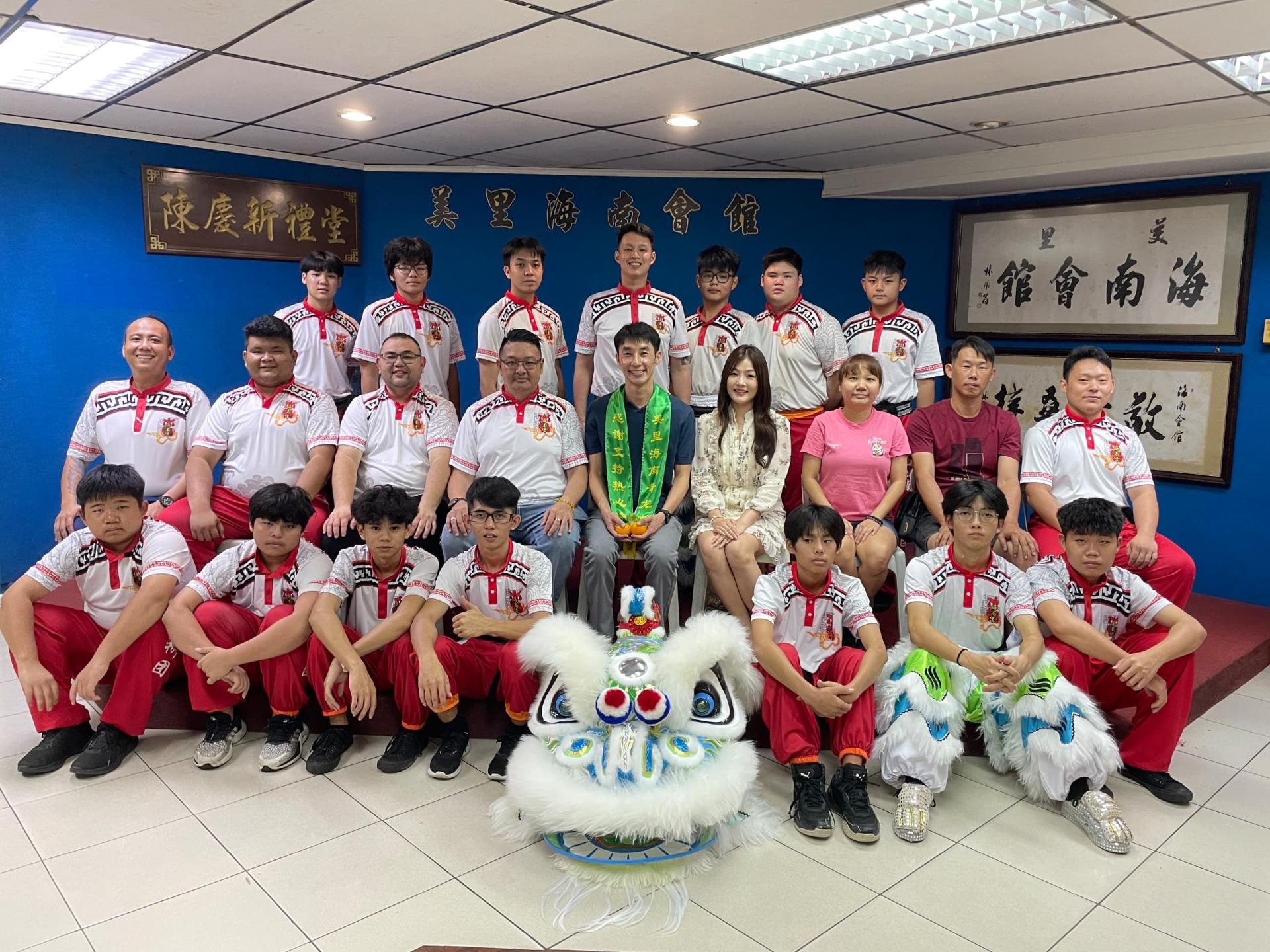赞助人梁氏（中）与海南会馆青年团龙狮团成员合影。