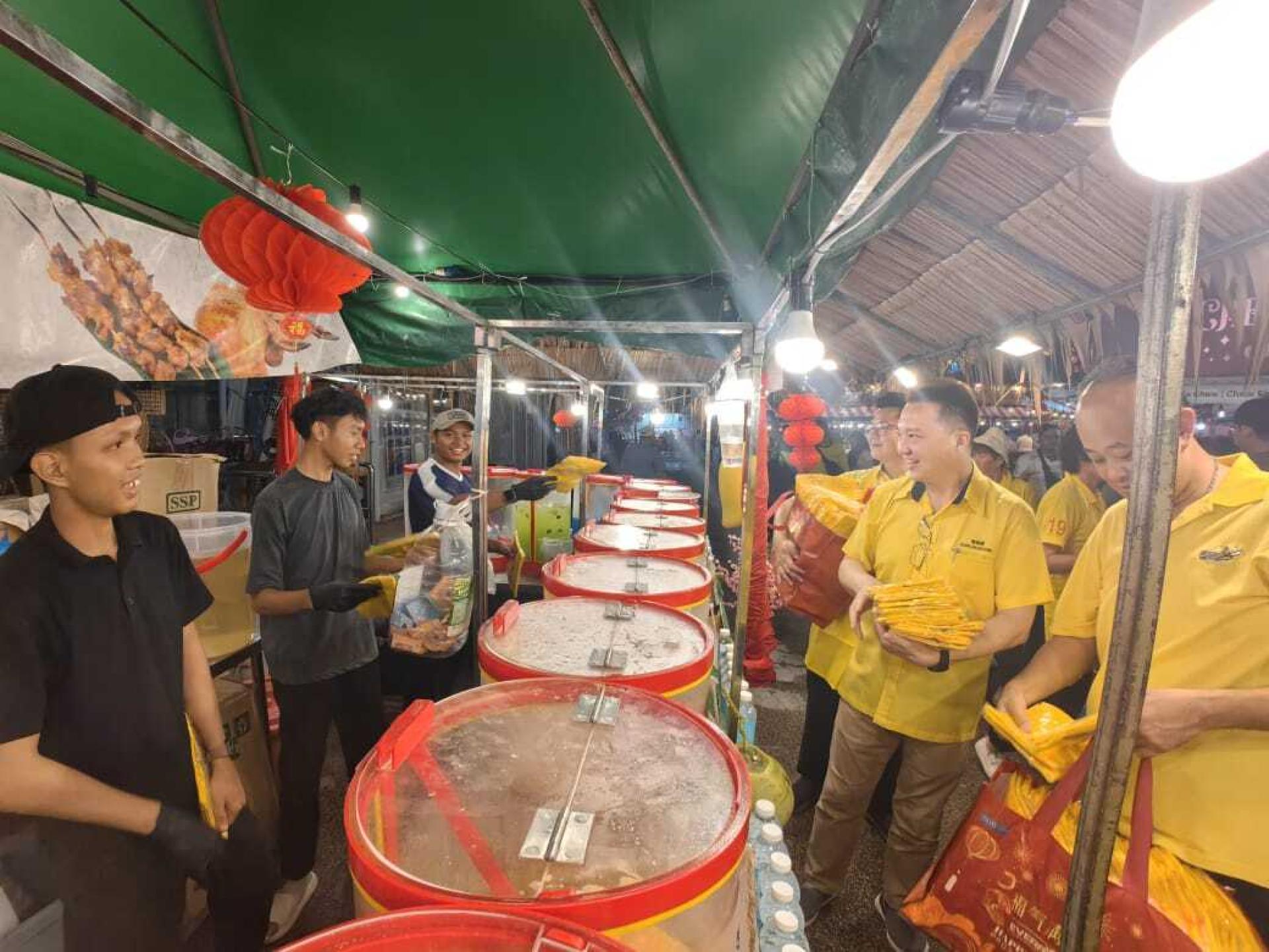 砂旅游部副部长陈超耀的服务团队，右起砂人联党卑尔骚支部宣教秘书兼美里市议员陈立仁、砂人联党卑尔骚支部秘书兼市议员谢家梁及砂人联党卑尔骚支部青年团团长兼市议员刘奕杰走访美里缤纷市集进行派送围裙予小贩。