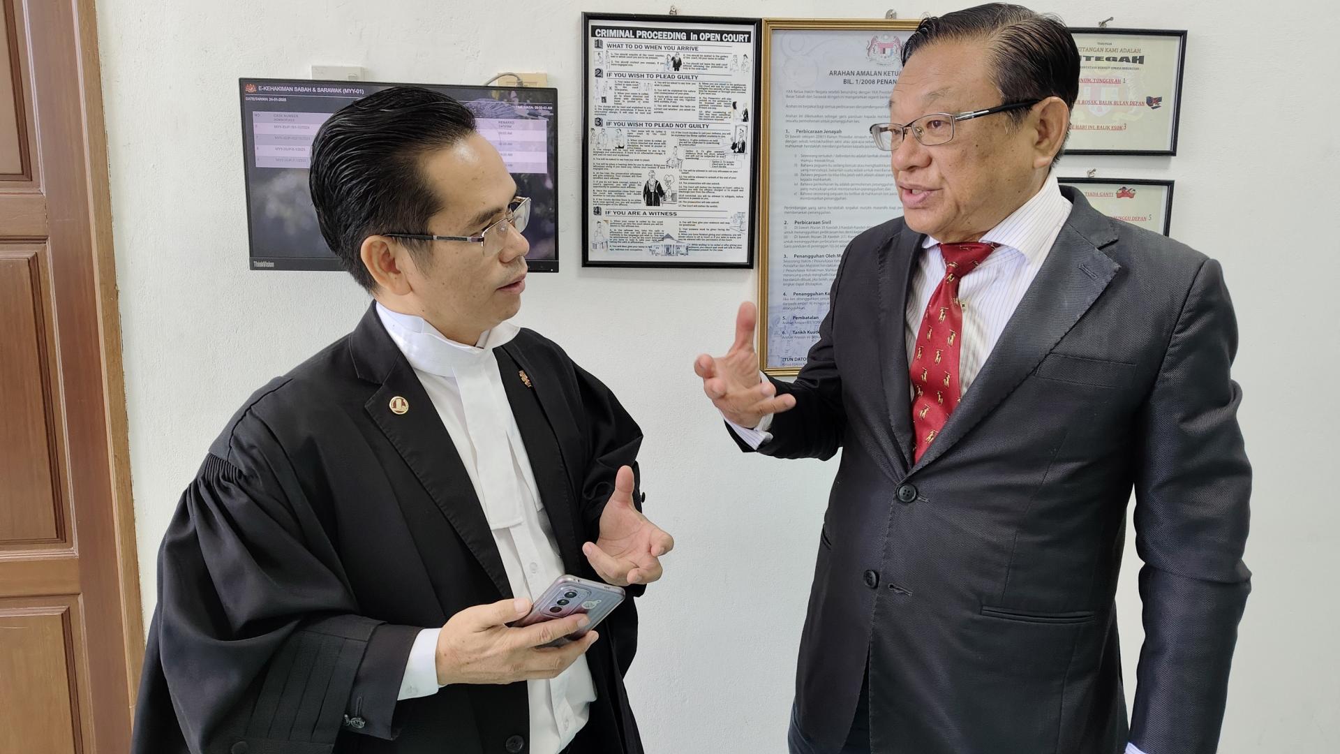前美里区国会议员张有庆（右）与其代表律师阿本瑞（左）在高庭外讨论案件。
