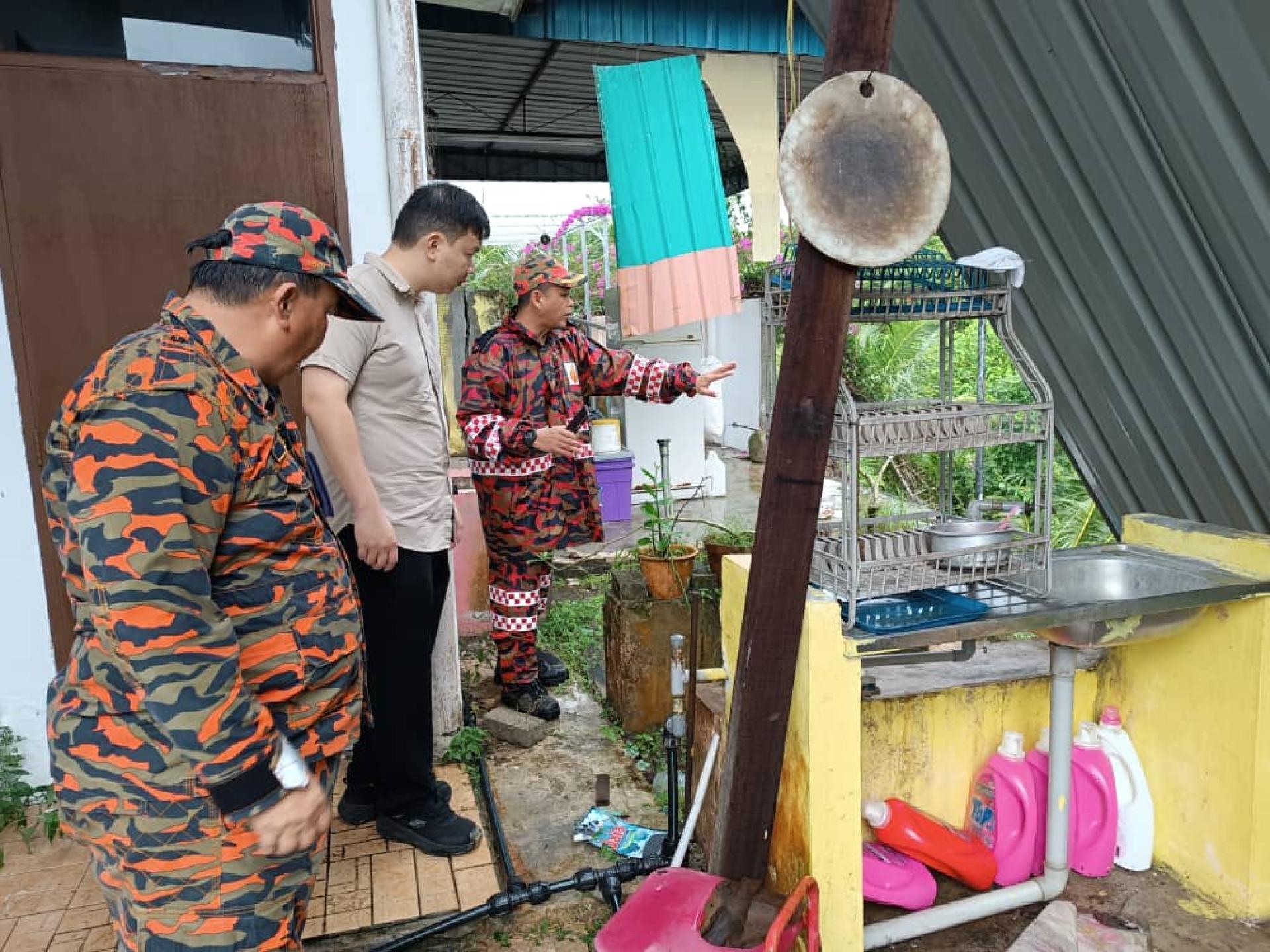 美里国会议员赵俊文（左）与消拯人员视察山泥倾泻情况。