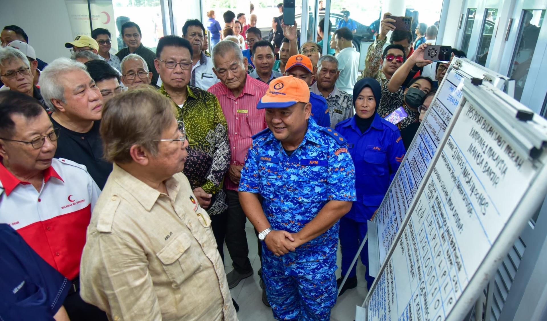 砂总理阿邦佐哈里（左）聆听美里红新月会的临时灾难安置中心汇报。
