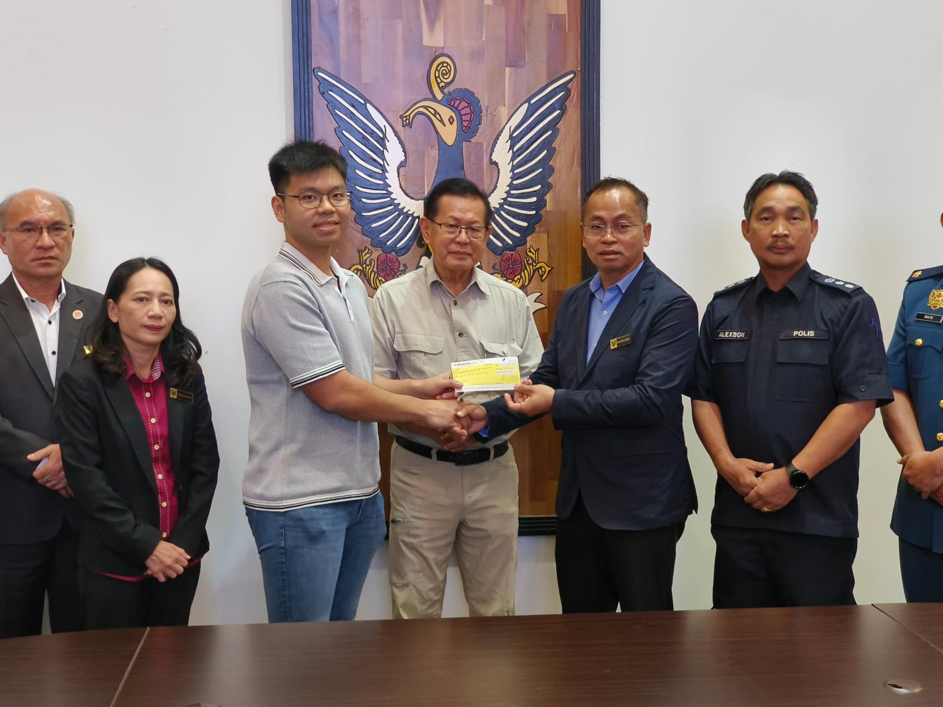 企业家潘伟康（左3）在拿督斯里李景胜见证下，将20万令吉支票移交给美里省灾难管理委员会主席卡隆鲁安。