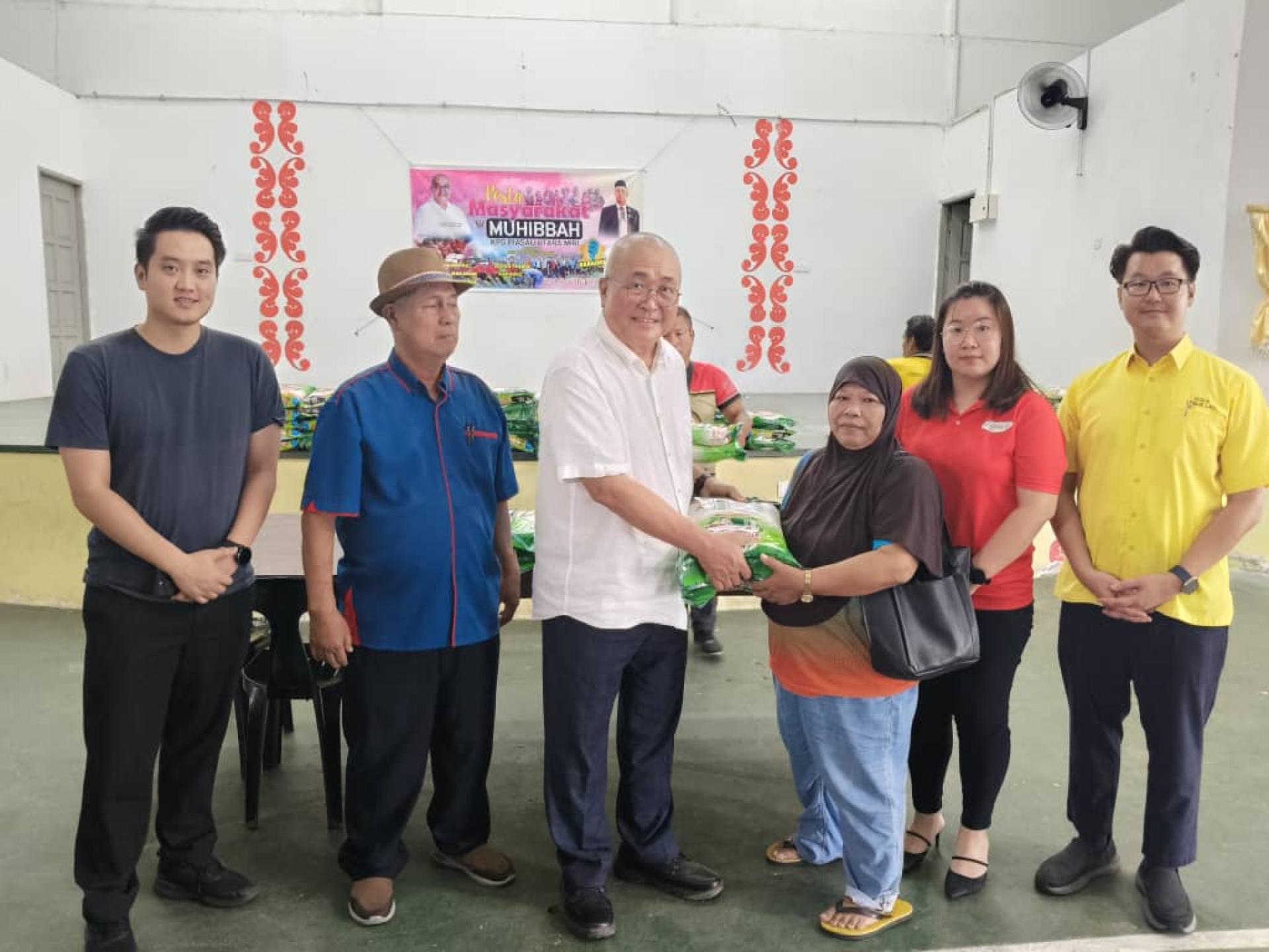 美里市长兼埔奕区议员俞小珊（左3）移交白米予其中一名灾黎。